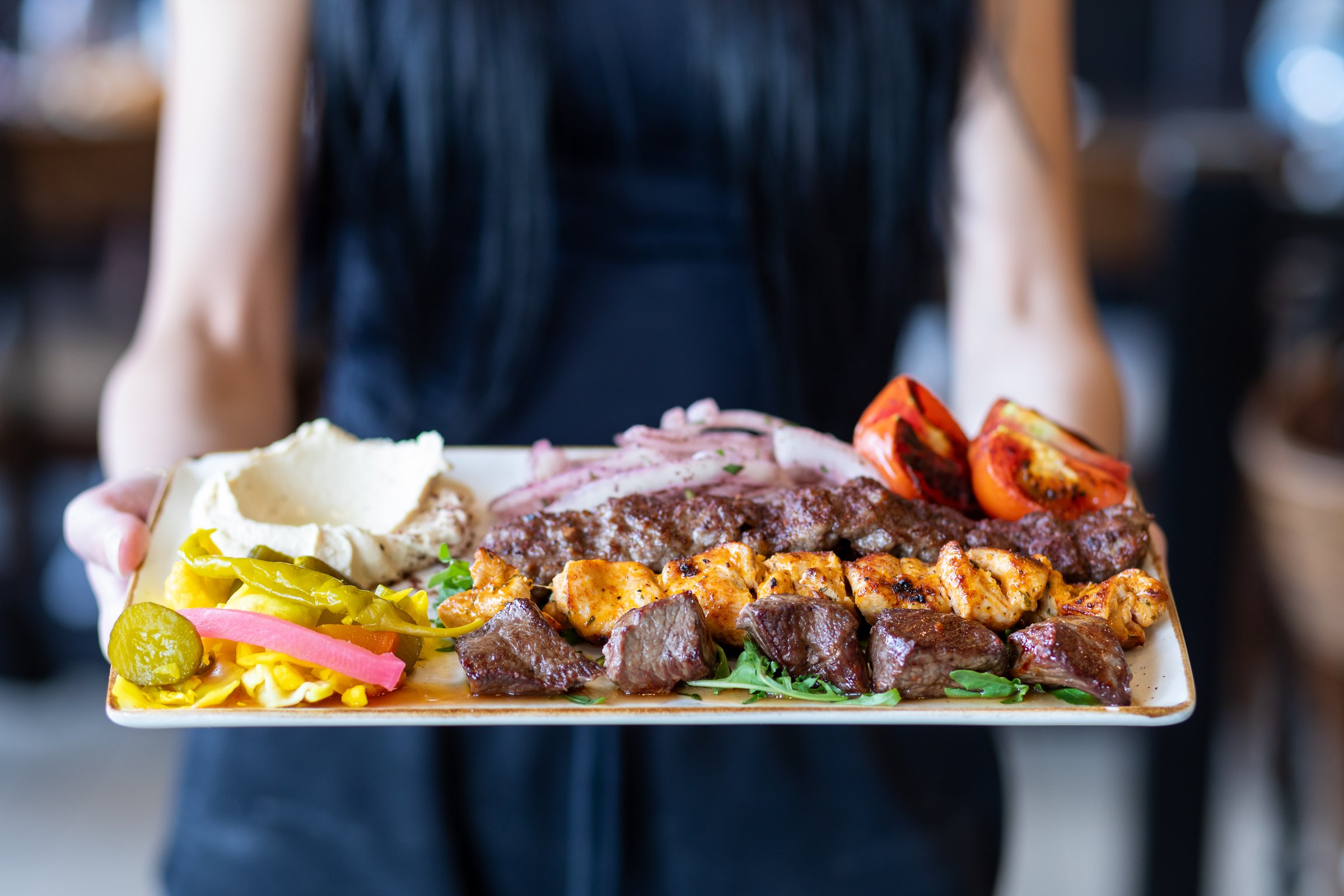 Delicious, freshly-cooked Turkish street food is seen in a modern, brightly-lit takeaway restaurant.