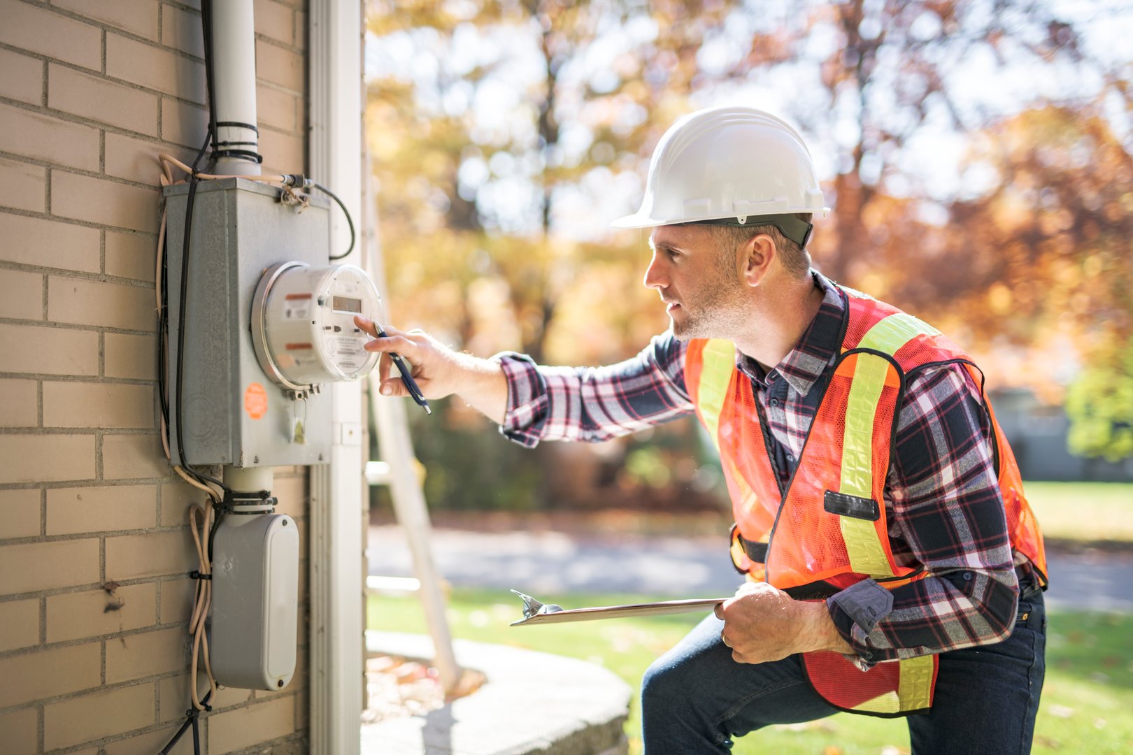 A man with hard hat standing in front of a electric panel