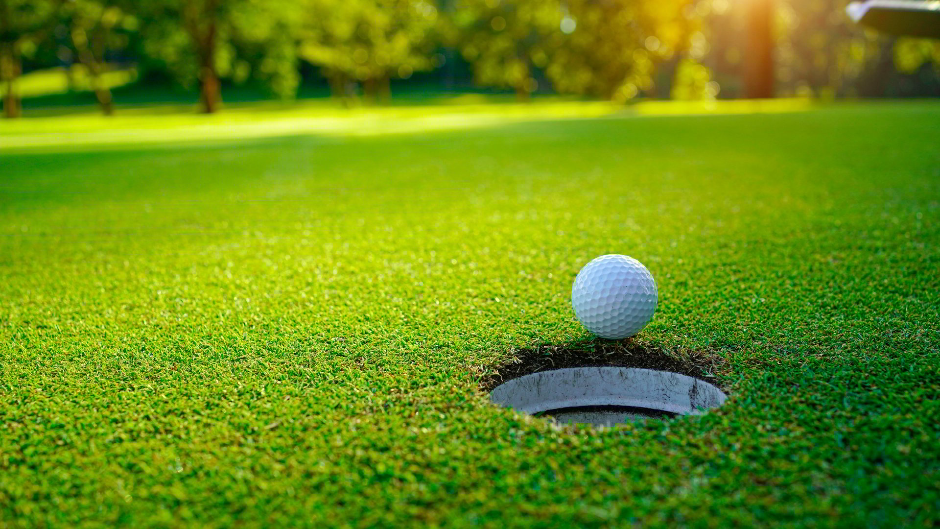 Golf ball is on a green lawn in a beautiful golf course with morning sunshine. Ready for golf in the first short.