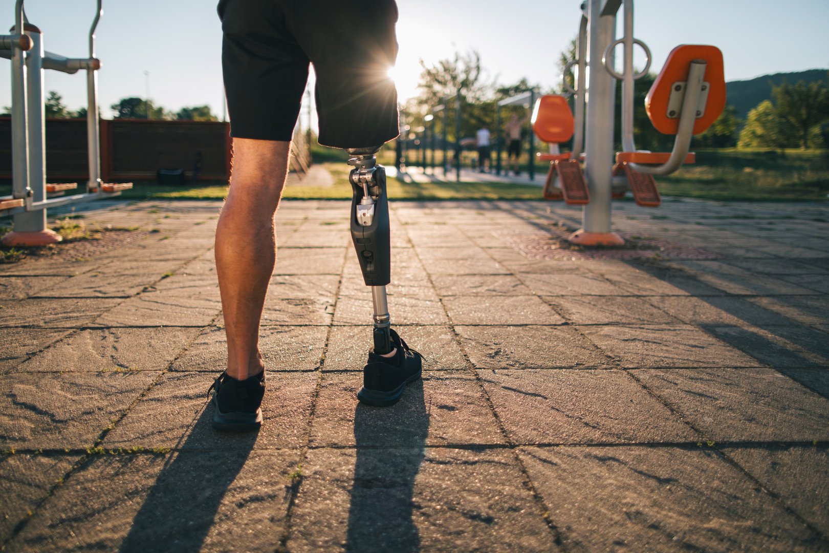 Close-up  of athlete amputee's leg, showcasing a prosthesis during exercising in the open outdoor gym.