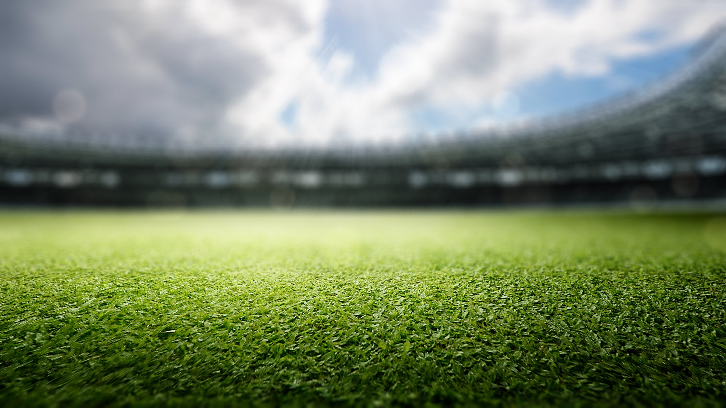 Empty football stadium with green field and blue sky. The field is ready for a game. Concept of Professional sport, Competition, Championship and match. Soccer stadium field background