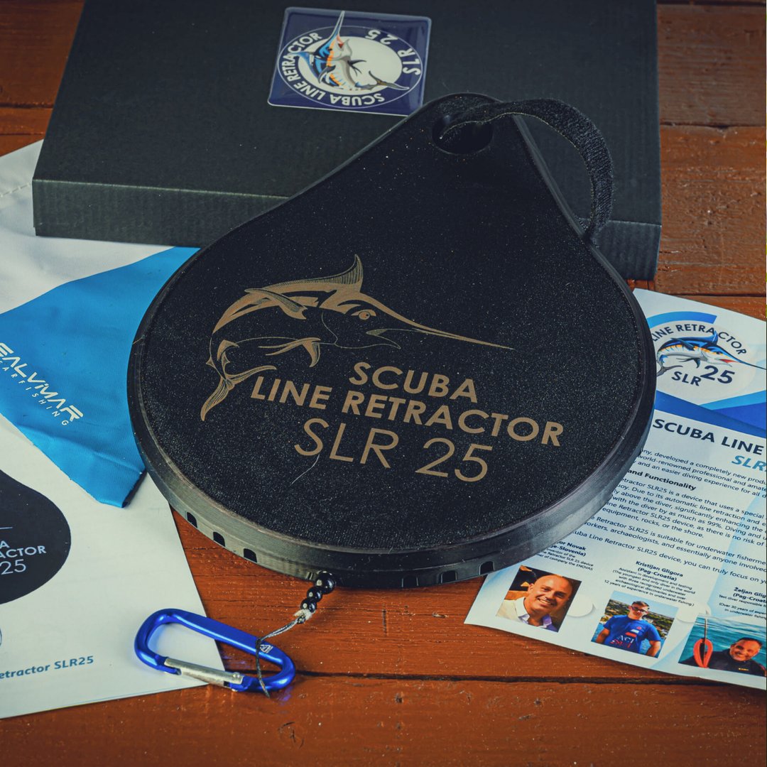Scuba Line Retractor SLR 25 with packaging, brochures, and a blue carabiner on a wooden surface.