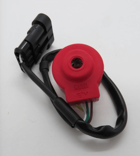 Red electronic component with black wiring and connector, possibly a sensor or actuator, on a white background.