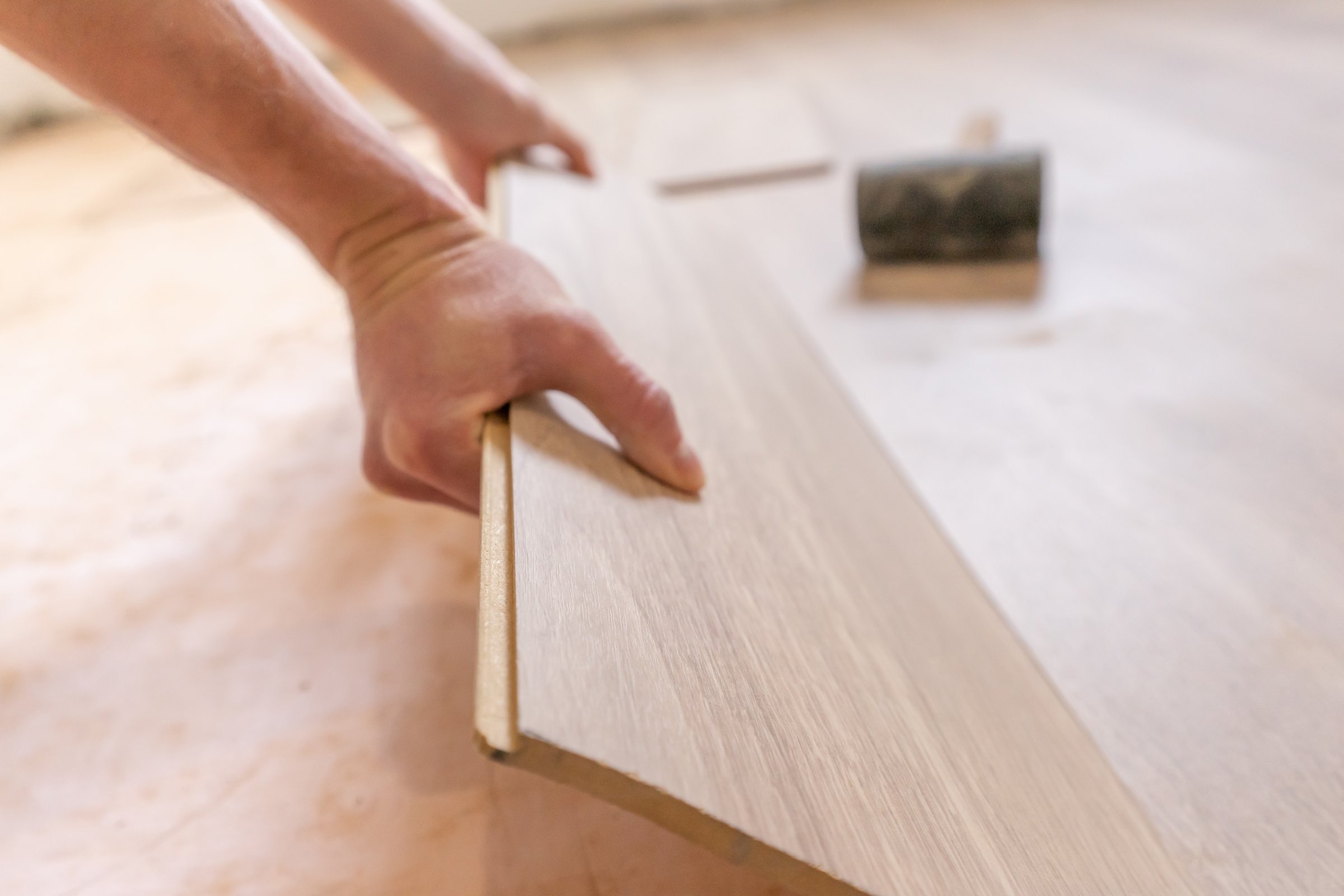 worker installing laminate flooring planks flooring planks on insulation underlayment. Home improvement and remodeling. Underfloor heating