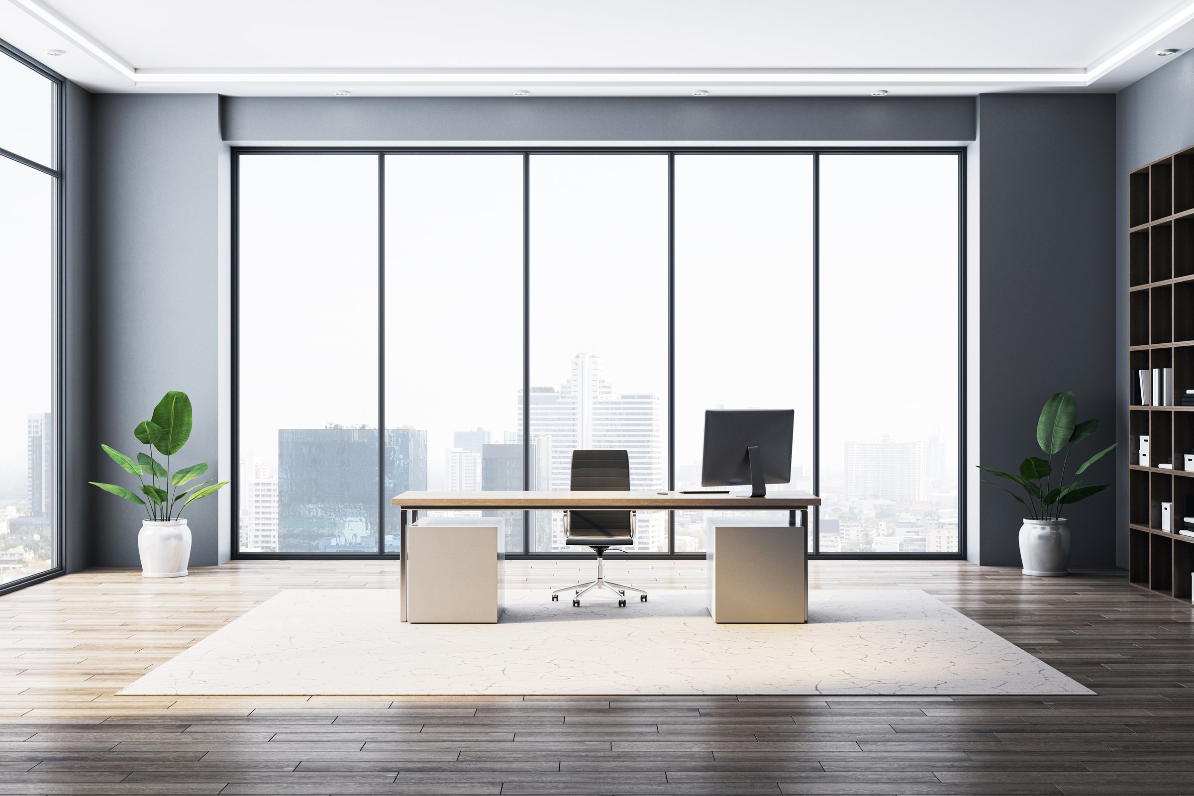 Sleek modern workspace with wooden flooring, glass windows, and urban view.