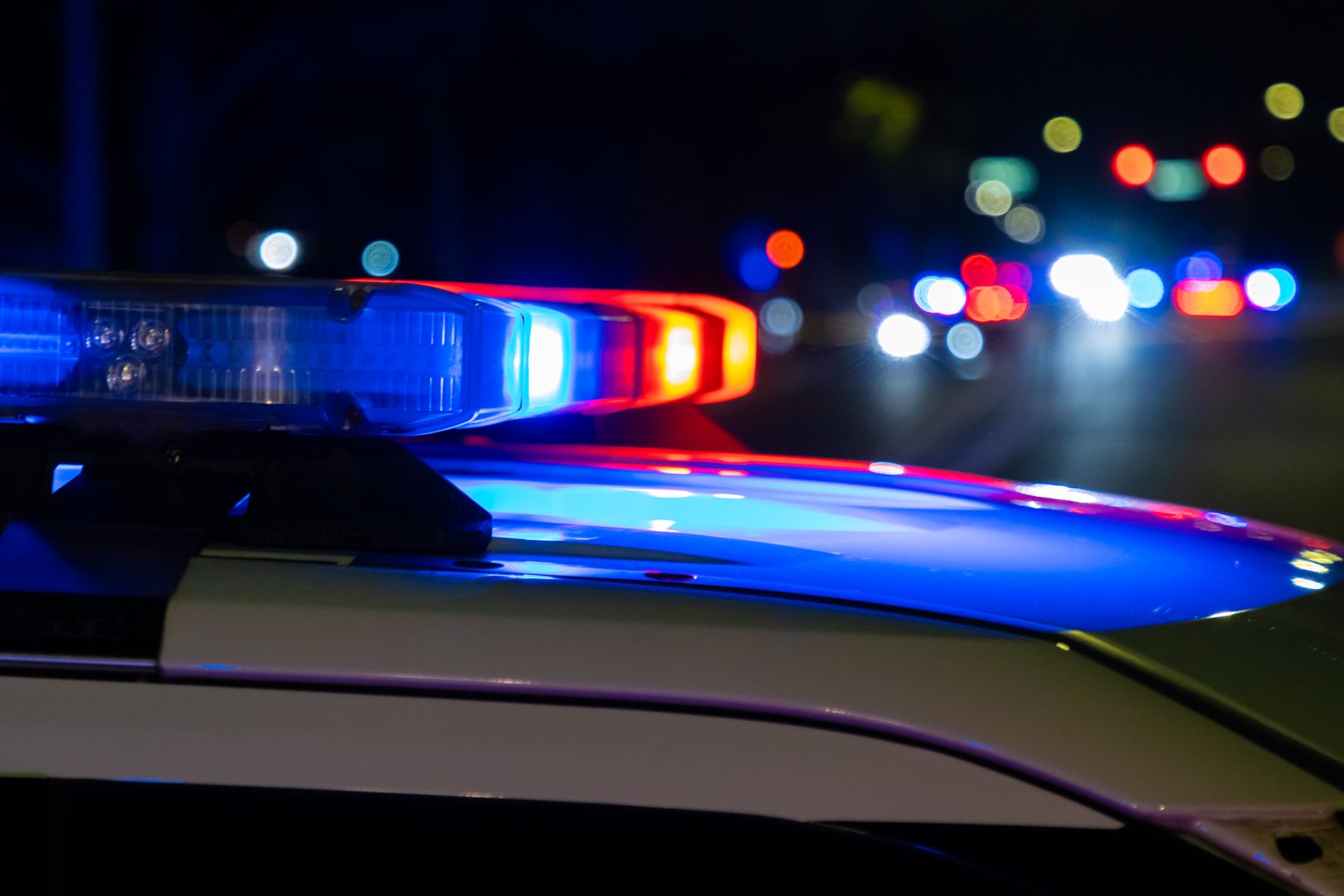 A crime scene in a city at night with blue and red police lights.