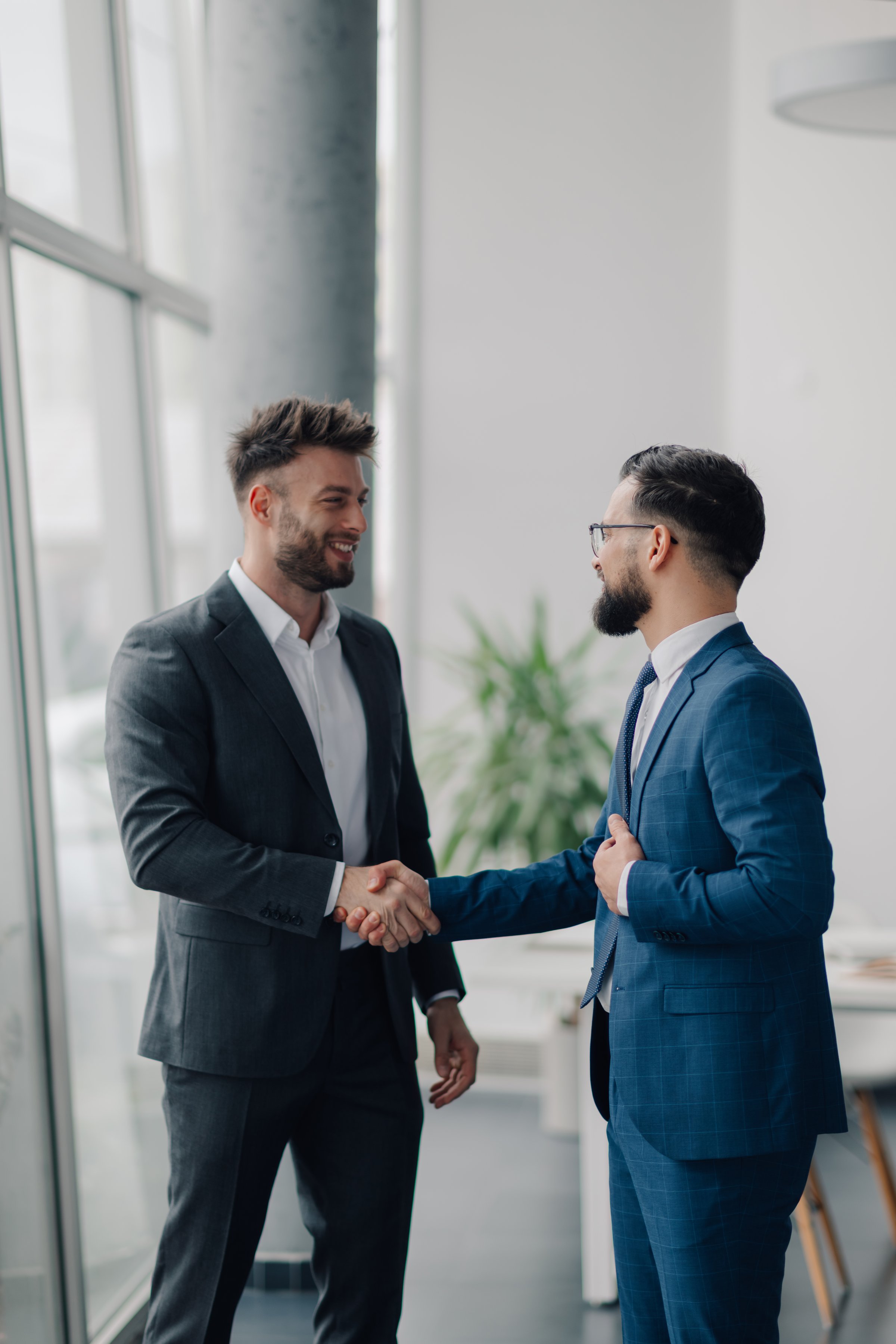 Two businessmen shaking hands after reaching an agreement in a modern office