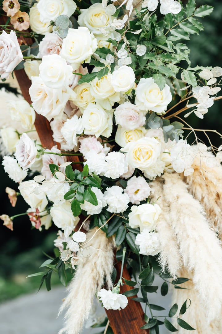 wedding triangular arch with roses on the background of nature.