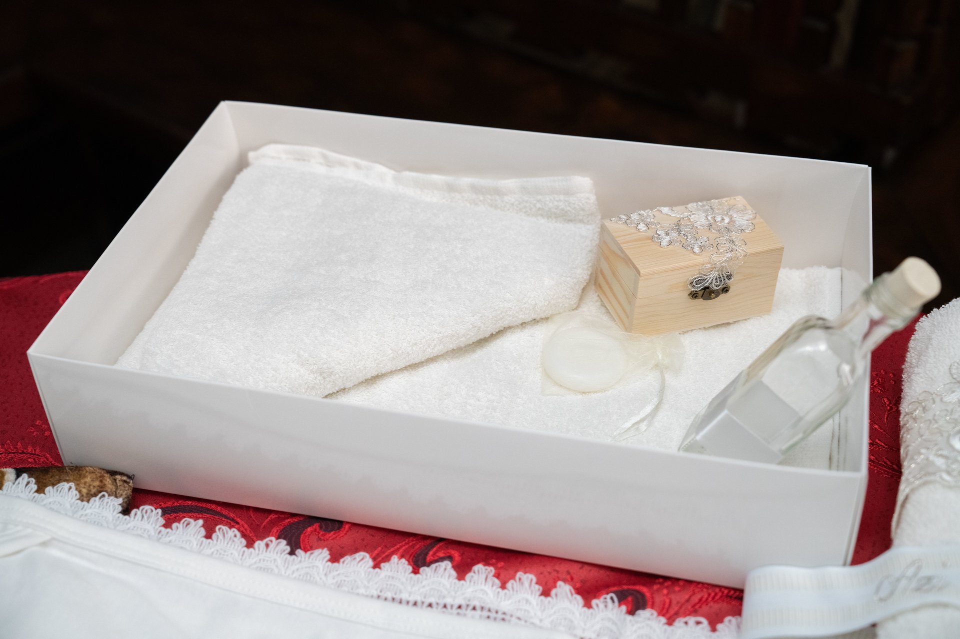 A closeup of a box with towels, a bottle of water and a small wooden box. Baptism concept.