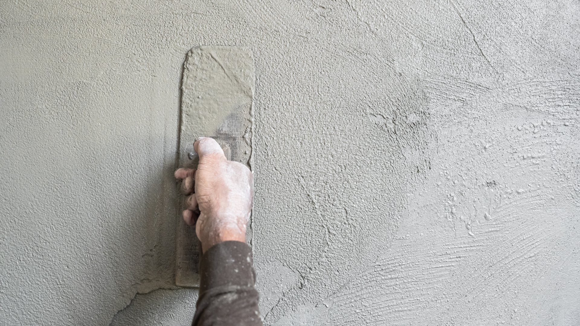 Hand worker plastering Cement wall background