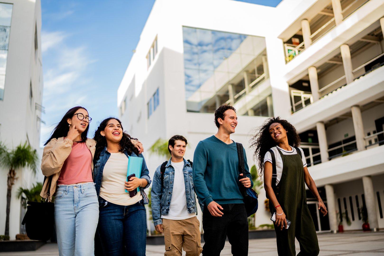 Young student friends talking and walking at campus