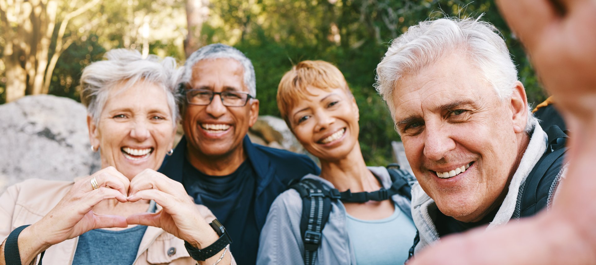 Nature, selfie and senior friends hiking together in a forest while on an outdoor adventure. Happy, smile and portrait of a group of elderly people trekking in woods for wellness, health and exercise