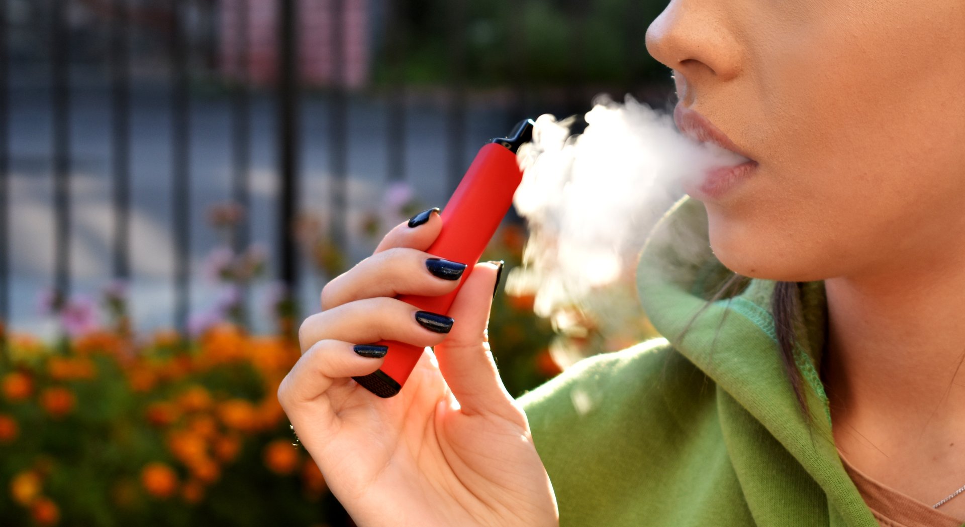 beautiful brunette smoke electronic cigarette in public places