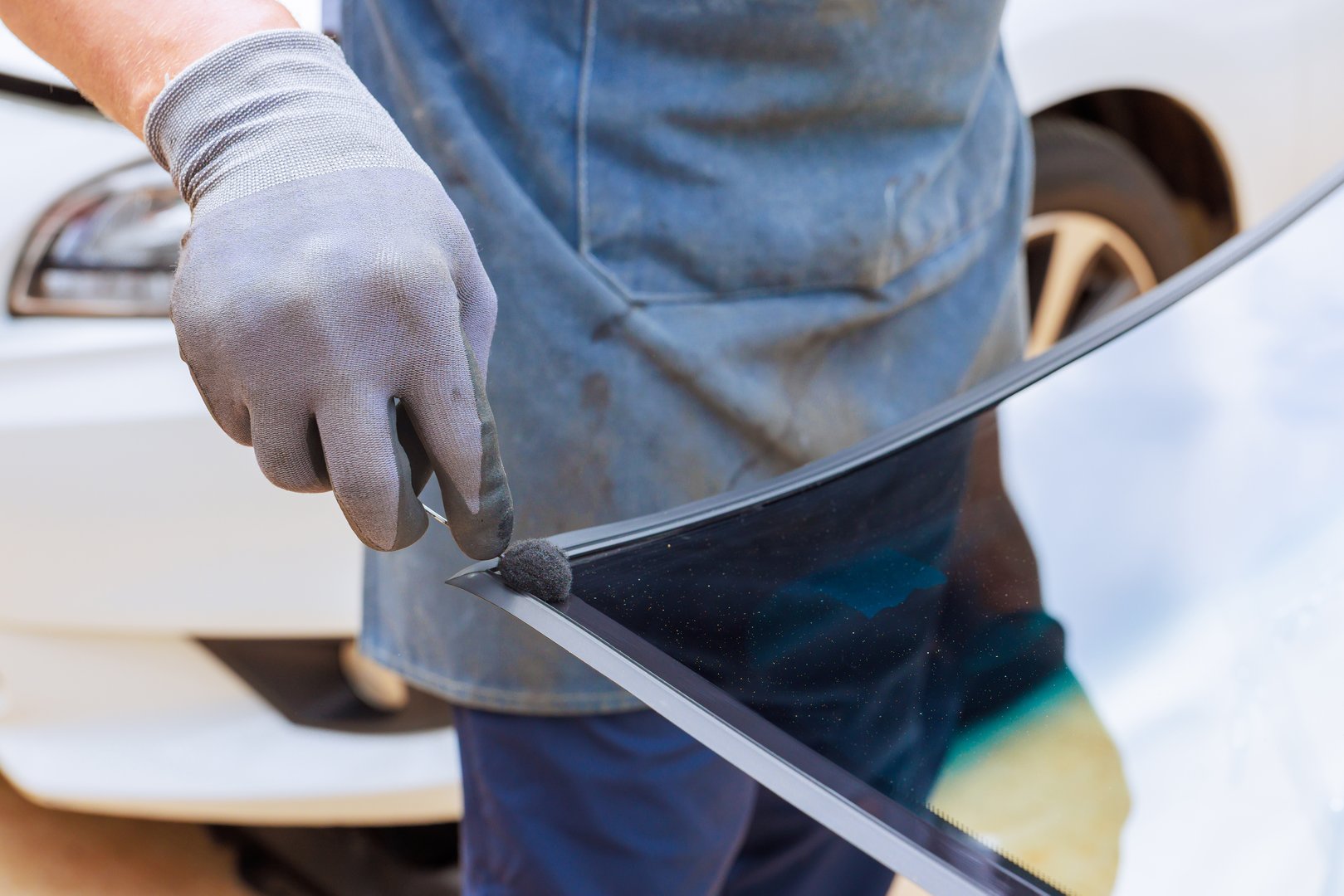 Skilled technician working on windshield replacement