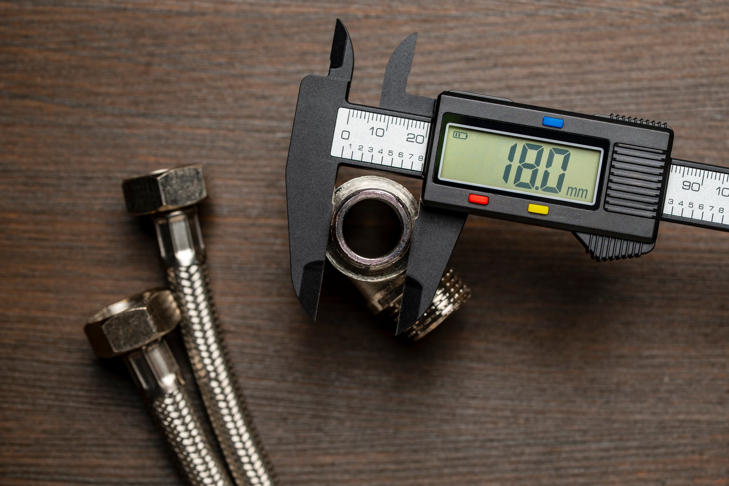 Measuring the diameter of plumbing adapters with an electronic digital caliper, close up, top view. Plumbing repair concept