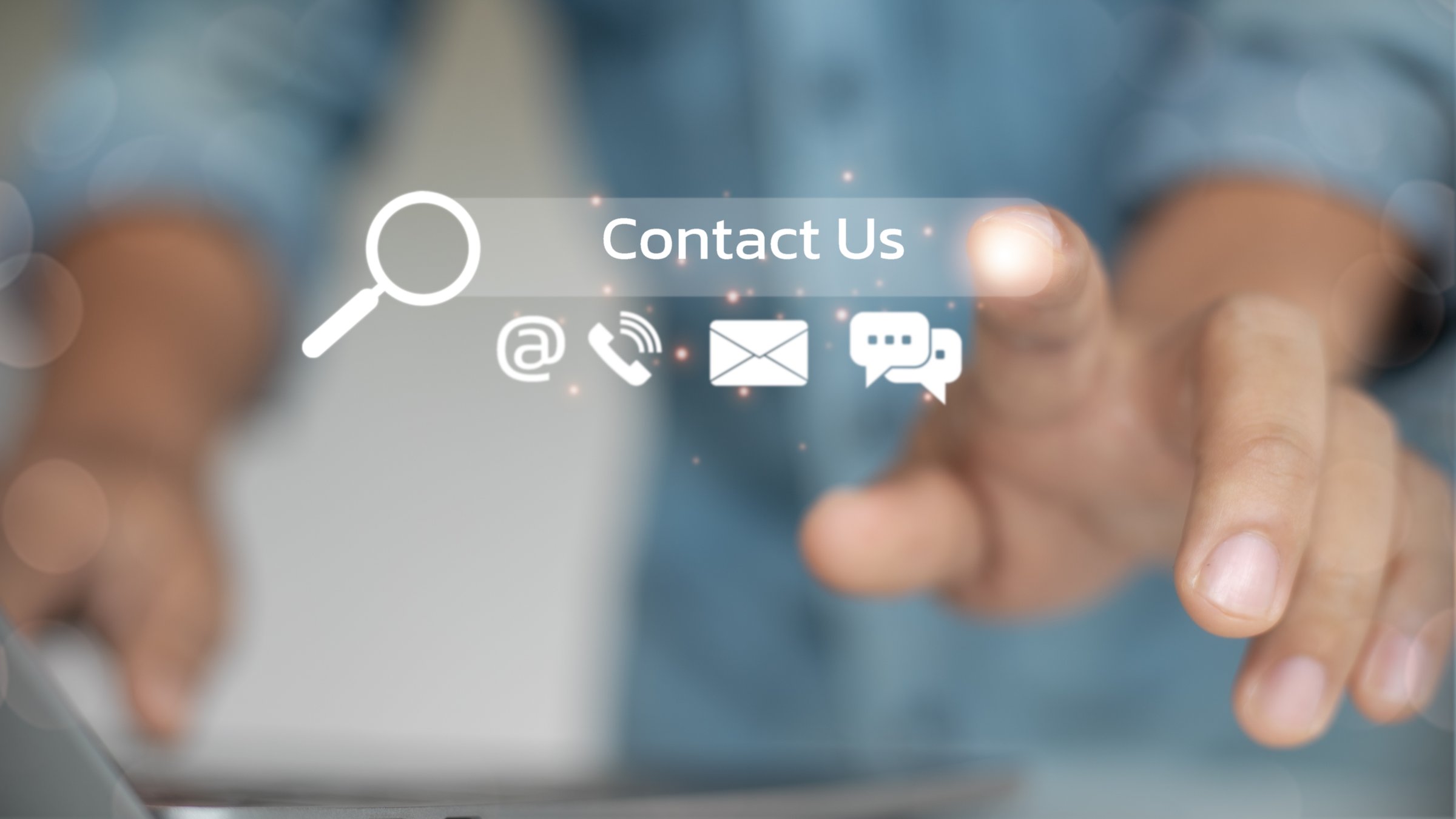 Close up of a hand pressing the virtual contact us icon with communication symbols