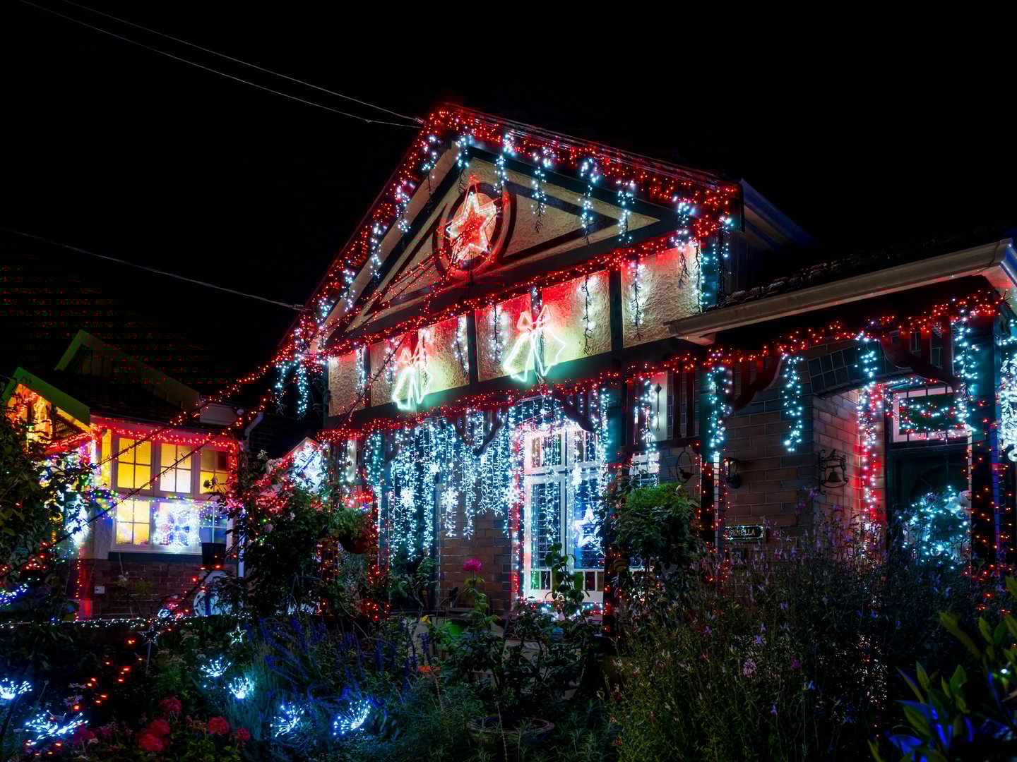 Sydney, Australia - Dec 26, 2024: Christmas decorations and other festive decorative lights in front of a suburban house. View from a public pedestrian walkway.