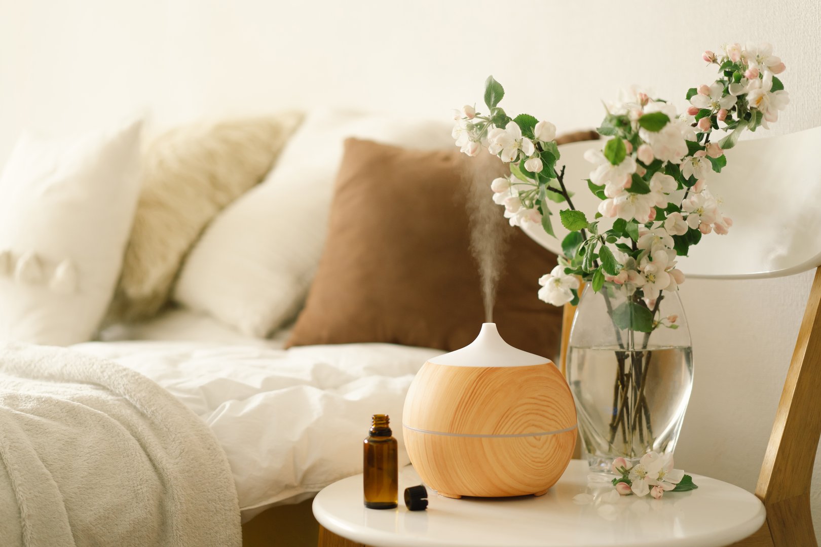 Aromatherapy Concept. Aroma oil diffuser on chair against in the bedroom. Air freshener. Ultrasonic aroma diffuser for home