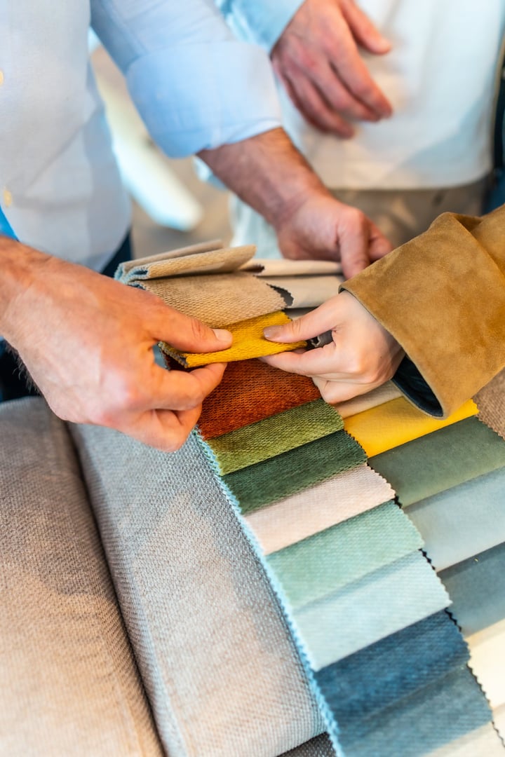 Customers and salesperson are selecting fabric samples for new furniture in a home improvement store