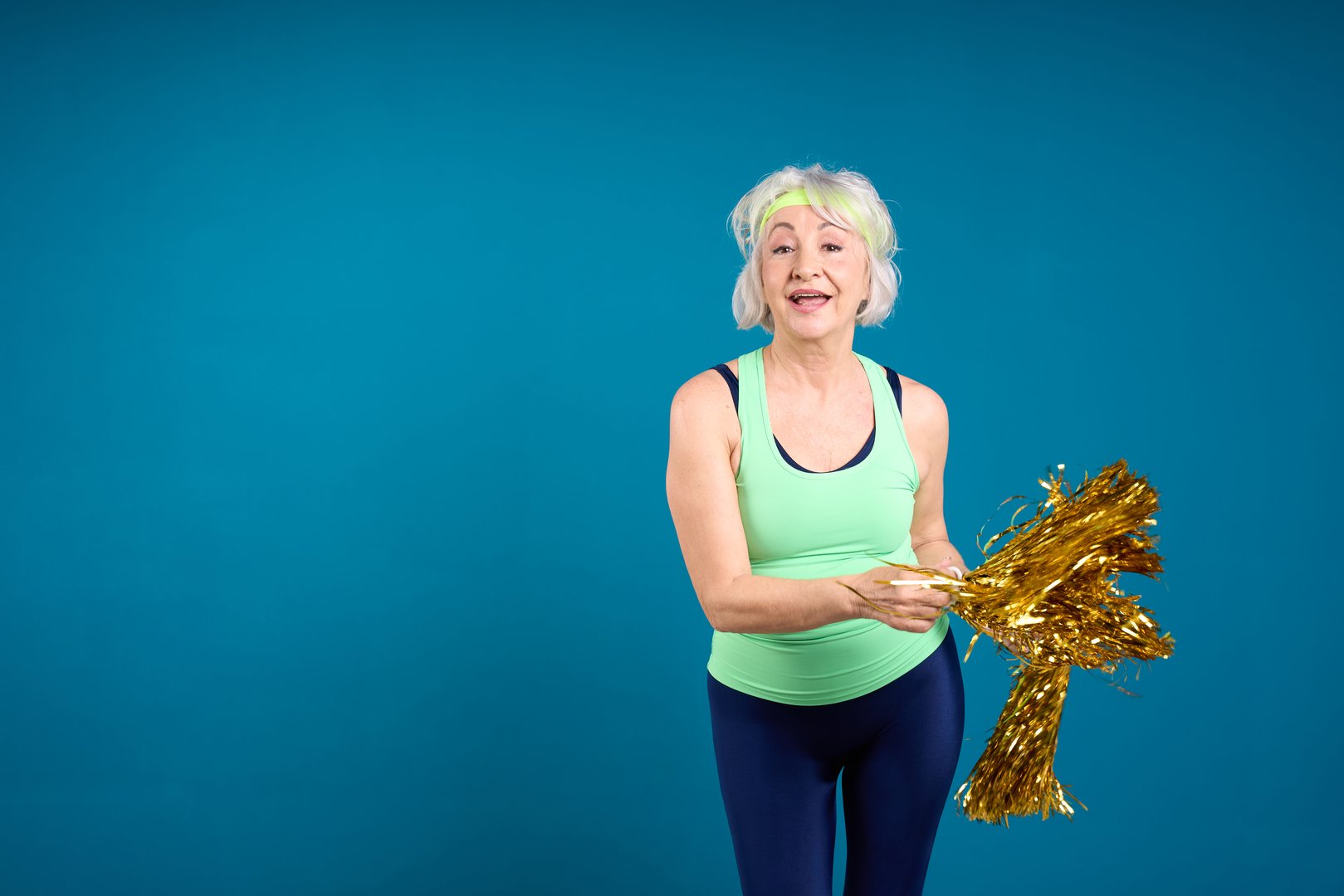Joyful Senior Lady with Golden Pom-Poms