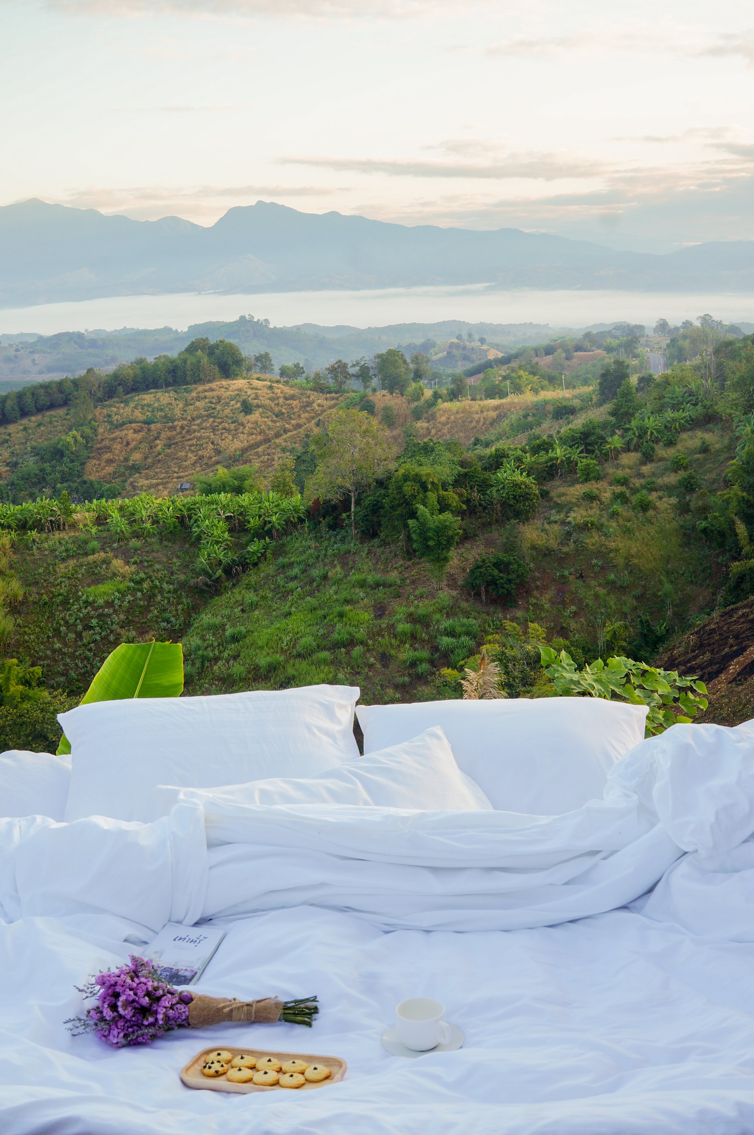 White pillow and blanket with mountain scenery view in morning. Outdoor on balcony terrace. Travel on holiday vacation.