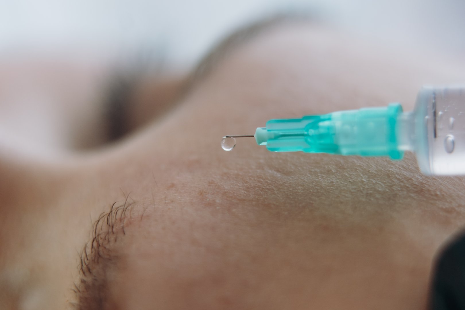 close up of professional hands making a rejuvenation injection into woman frown line