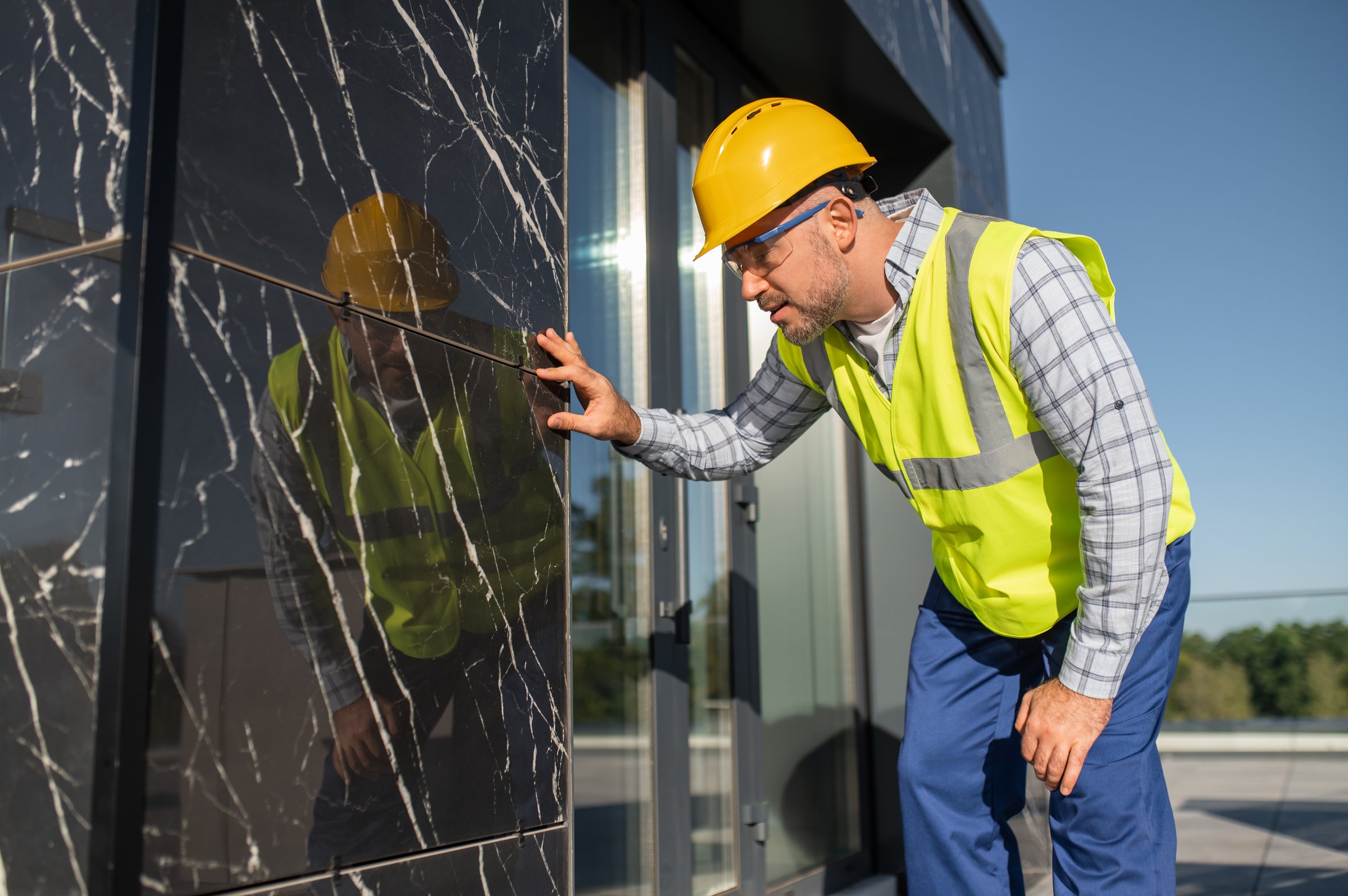 Technician checking construction details on building facade outdoors