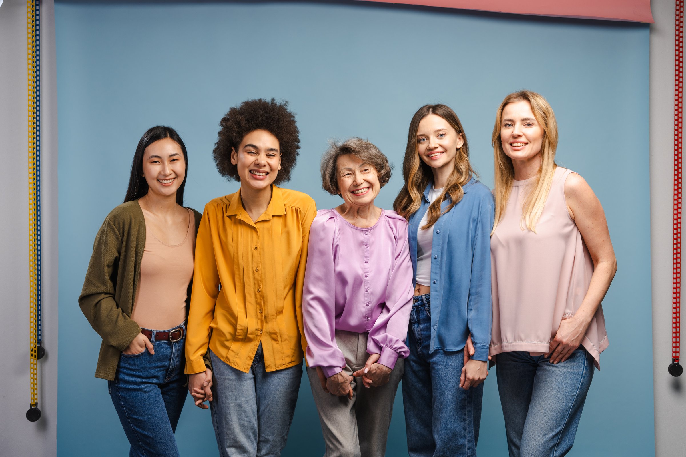 Five cheerful women of different ages and ethnicities are standing together, representing diversity and inclusion, creating a powerful and inspiring scene of female empowerment