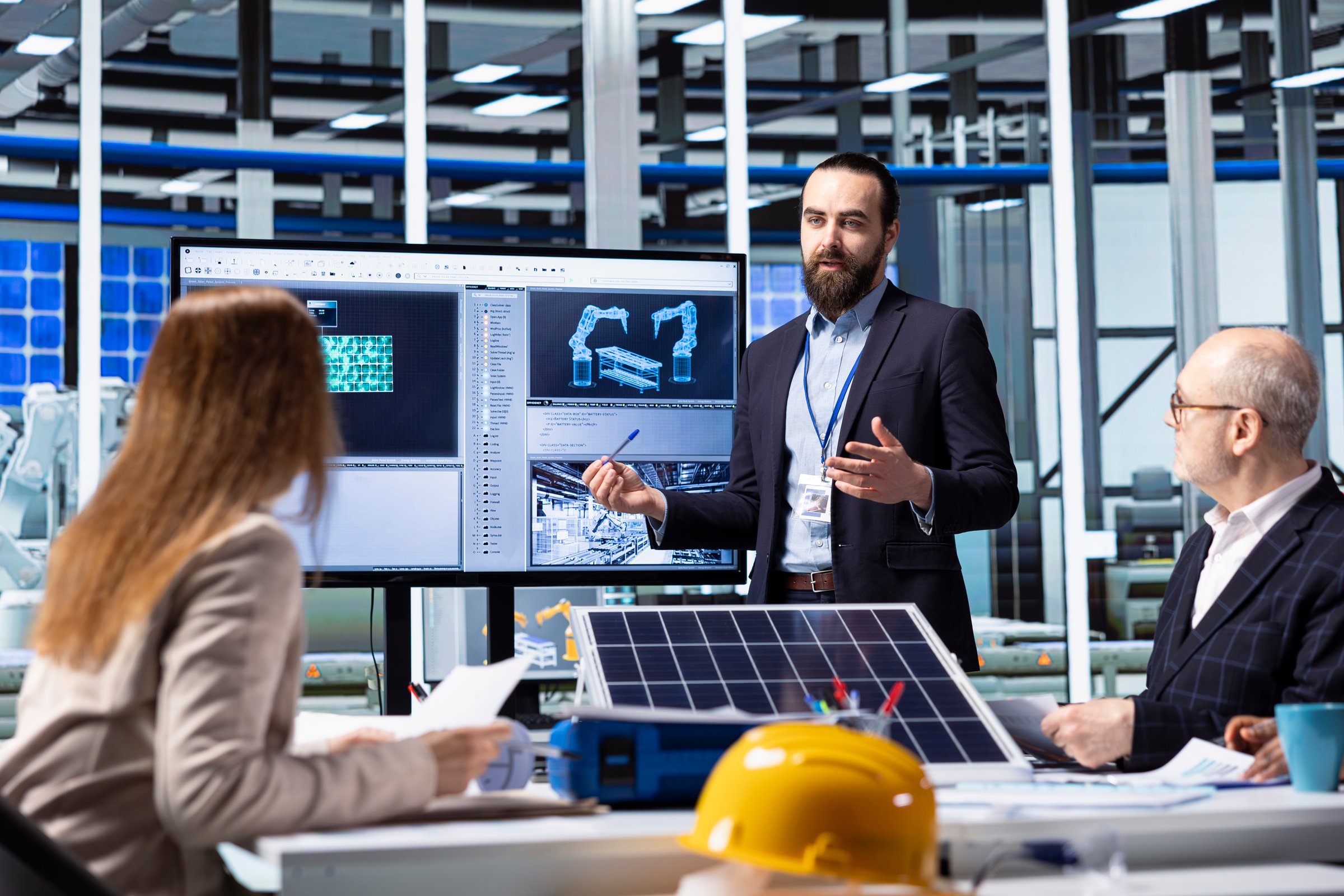 Photovoltaics factory executives planning strategic investment decisions, going over data. Investor and solar panels factory management team standing together discussing business data