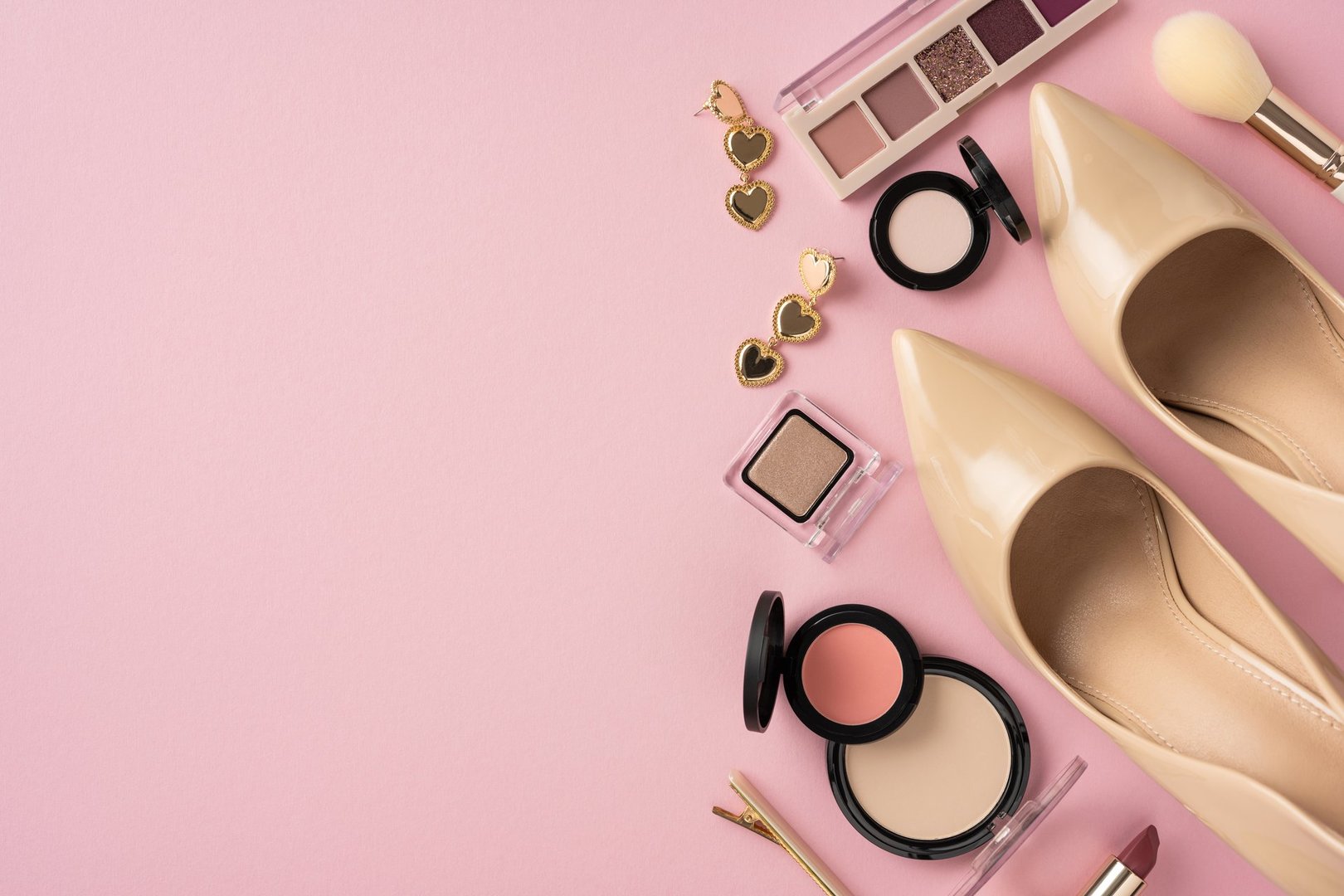 Flat lay composition including makeup items, shoes, and accessories showcasing a feminine aesthetic