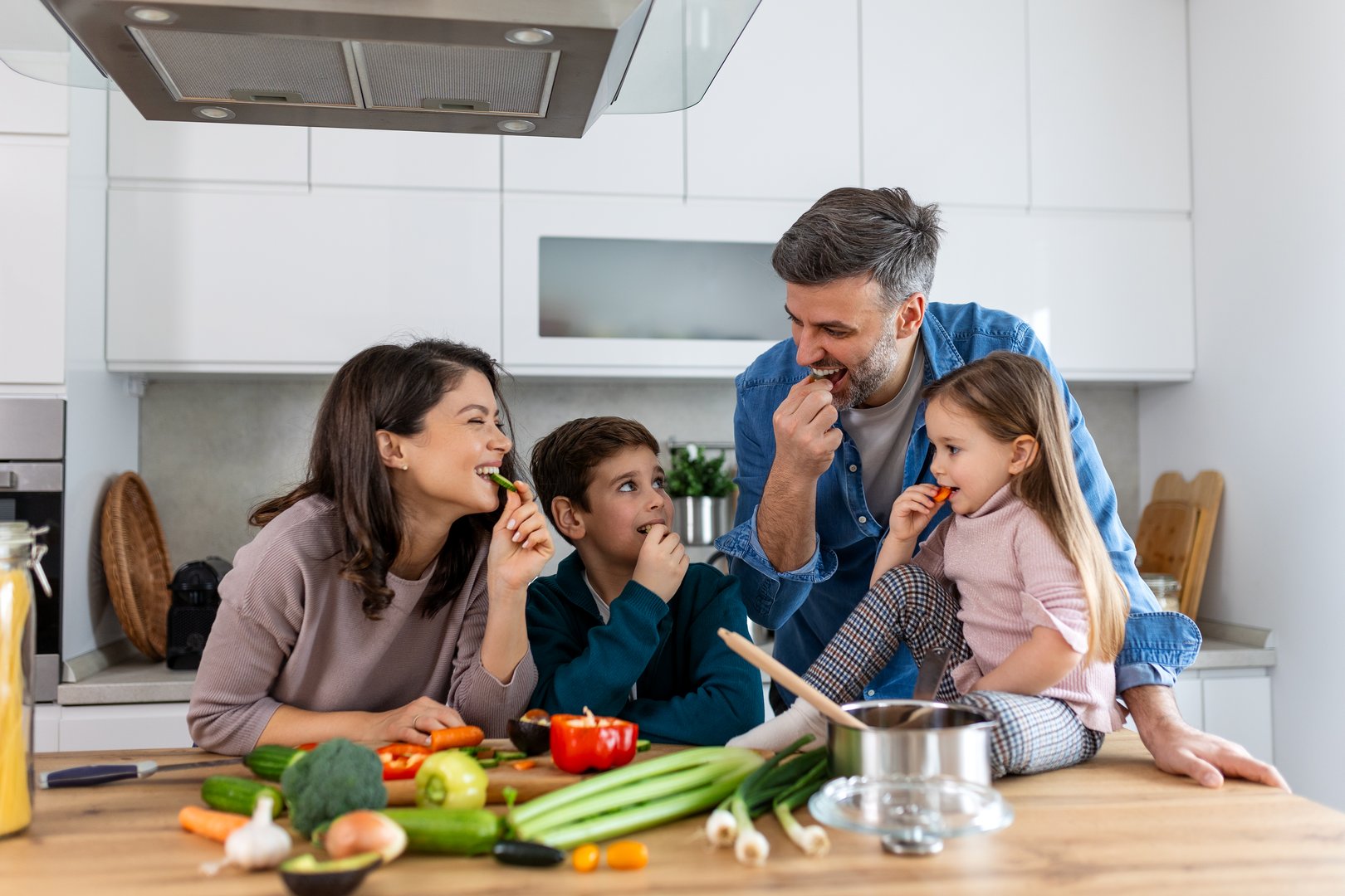 Family with adorable son and daughters gathered in modern kitchen cooking together. Enjoy communication and cookery hobby concept.