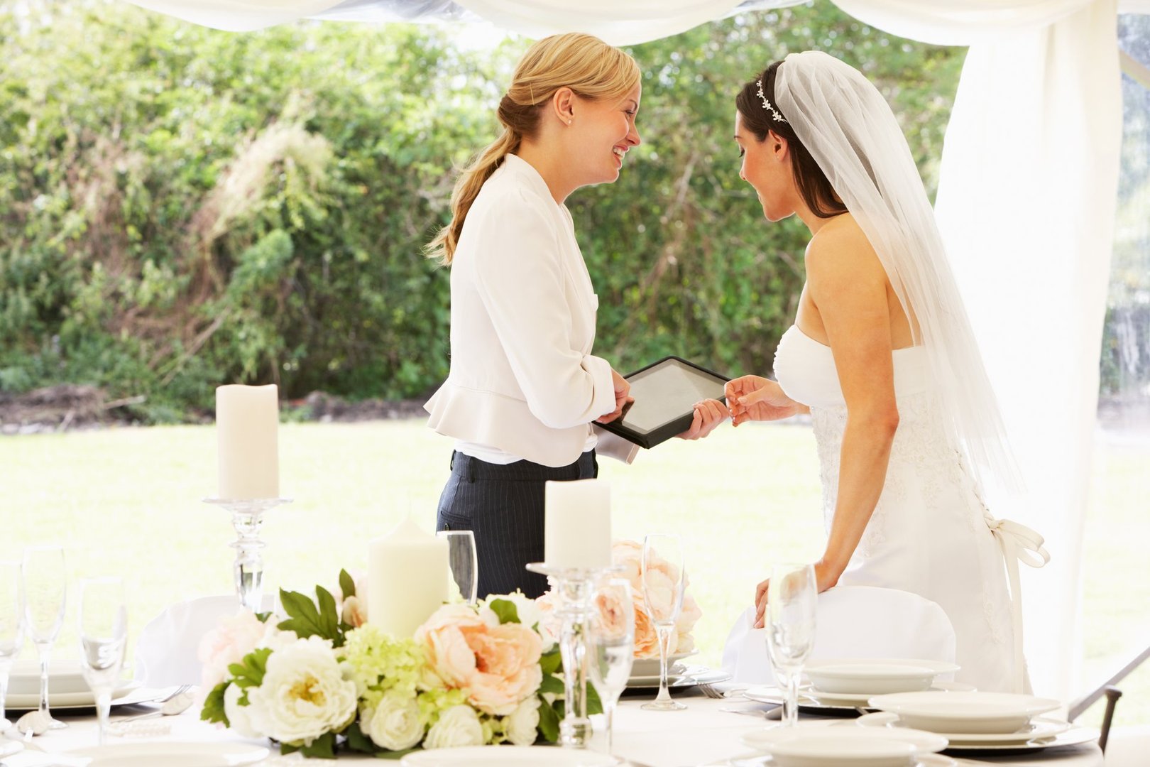 Bride with wedding planner using tablet