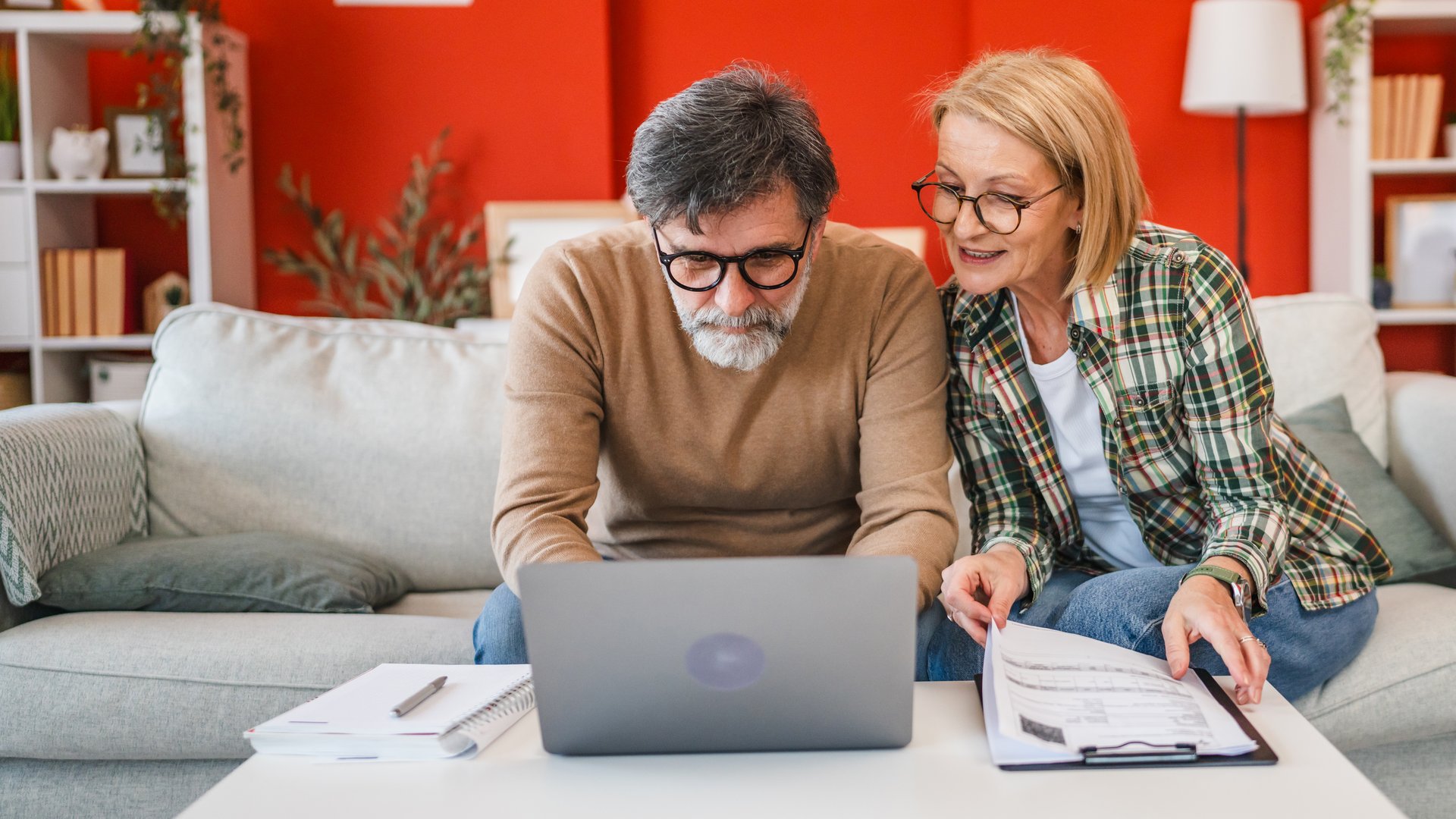 two colleague mature man and woman work from home together planning and research on laptop