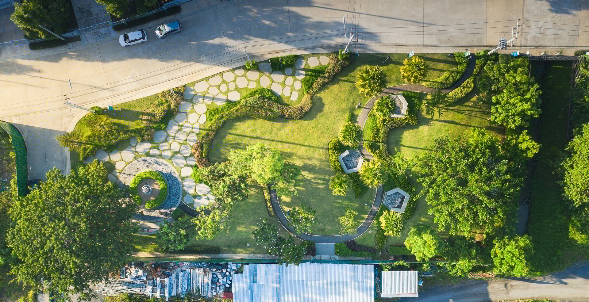 Garden and landscaping in aerial view. Consist of ornamental and decorative object i.e. lawn, grass, building, furniture, tree, bush, flower and fountain. Include paving stone, concrete and asphalt.