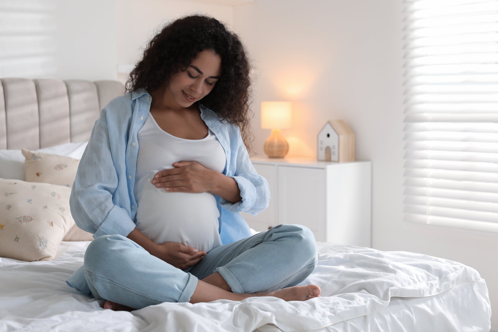 Portrait of beautiful pregnant woman on bed at home