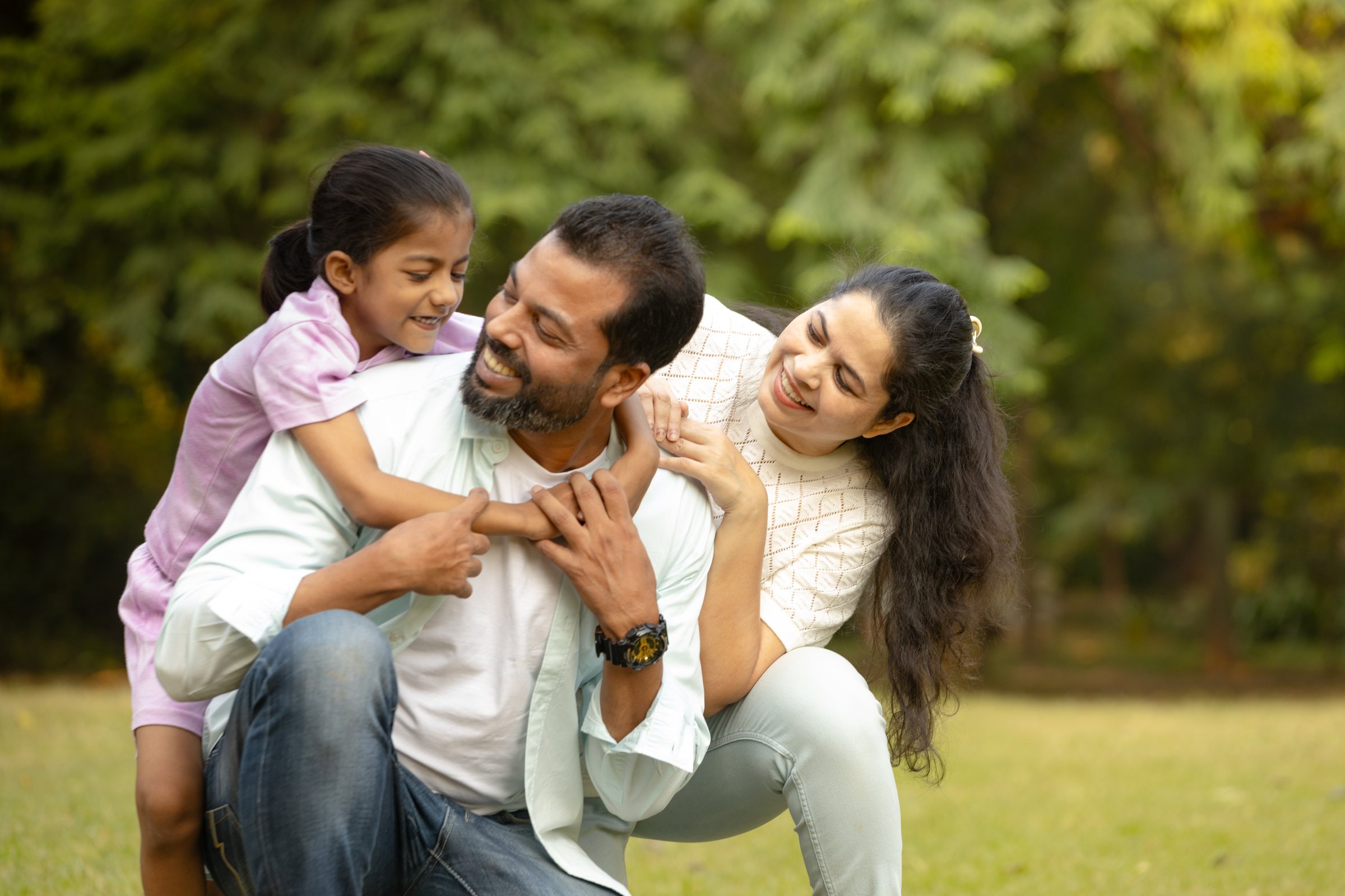 portrait of indian family outdoor candid moment, Joyful Family Piggyback Ride in Nature