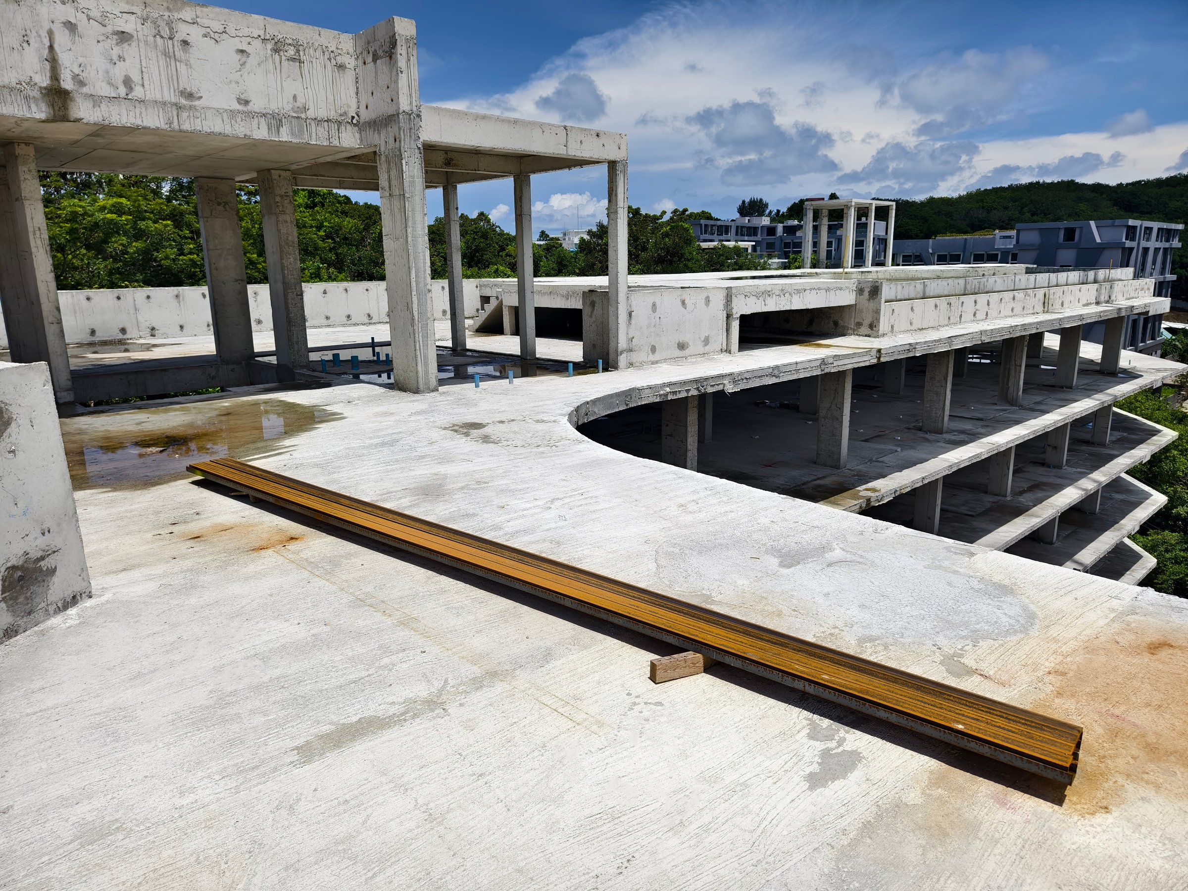 Large building with a roof pool of water under construction.