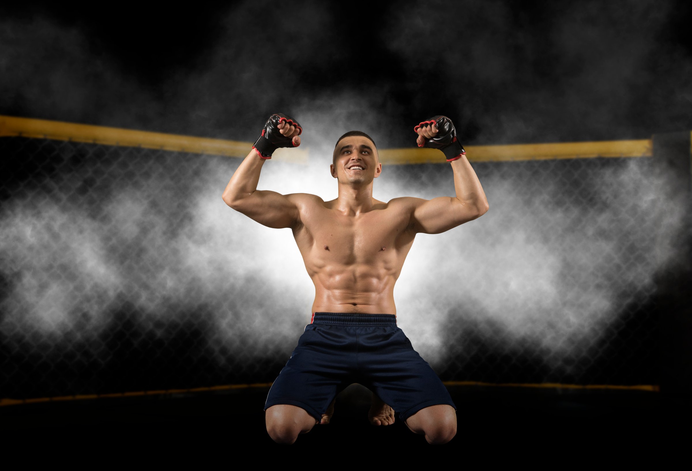 MMA fighter in cage celebrating win - Image