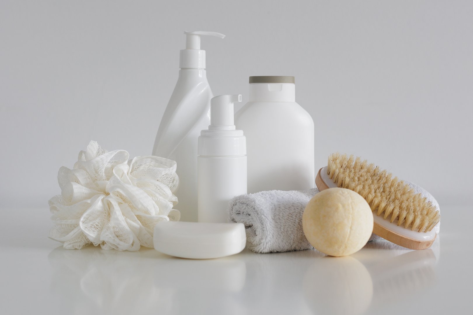 Ð¡omposition with bath accessories, cosmetic bottles, massage brush, sponge with soap and towel