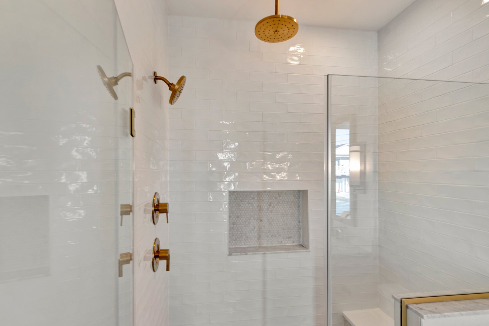 A white tiled shower with glass door for easy walk-in access