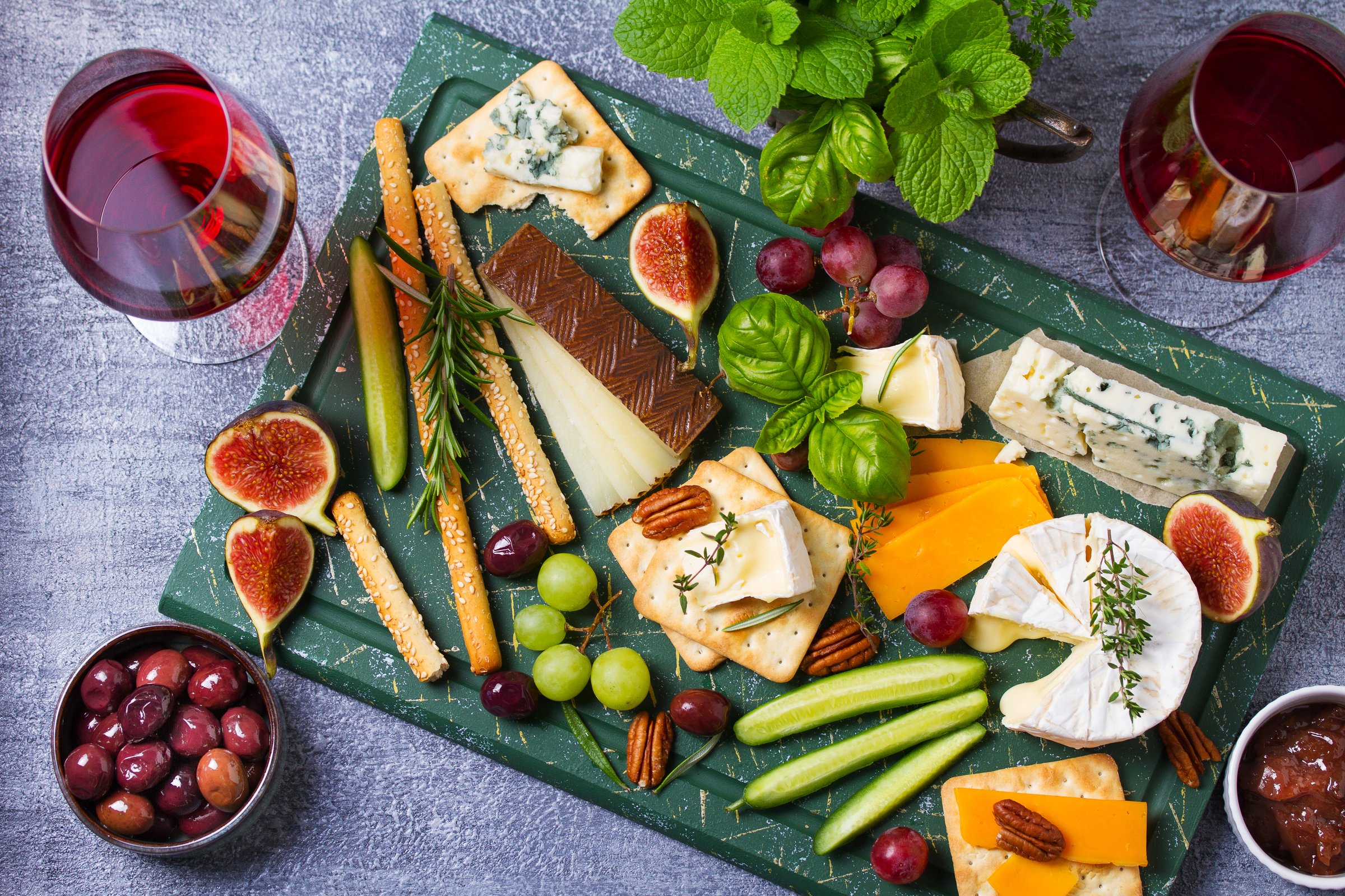 Assortment of various cheeses. Cheese selection. Cheese platter served with grapes, figs, nuts and chutney. Wine glasses. Food for wine. View from above, top studio shot