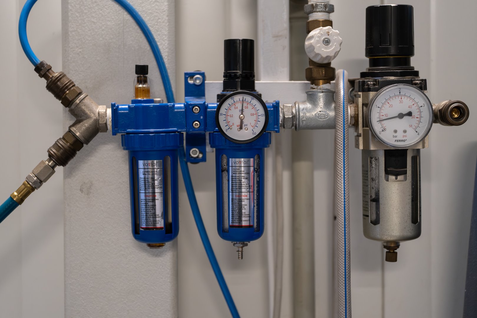 Krakow, Poland, November 2025. Pressure gauges and air filtration equipment mounted on a wall inside an automotive service station during a technical inspection process.