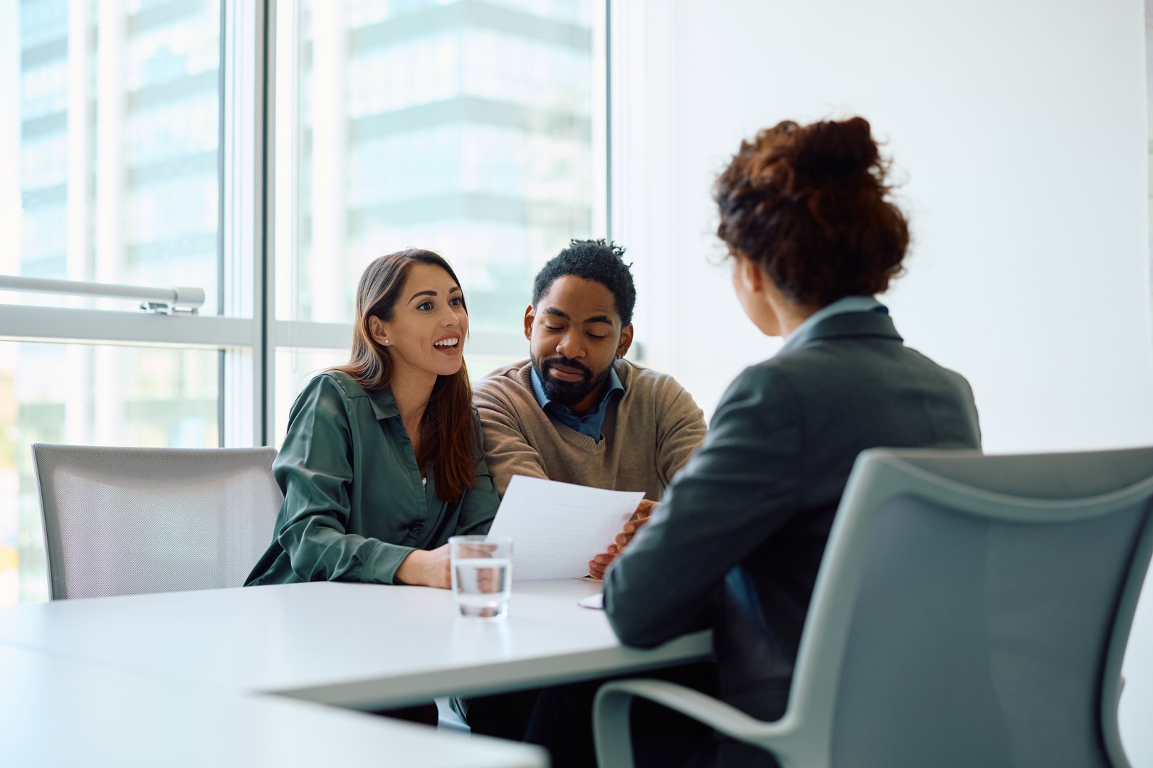 Young woman and her African American husband having a meeting with financial advisor in the office.
