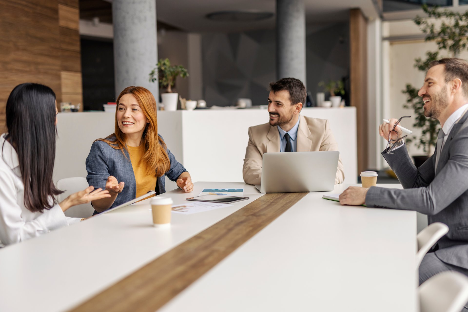 Team of businessmen and businesswomen sitting at boardroom and having sprint meeting.