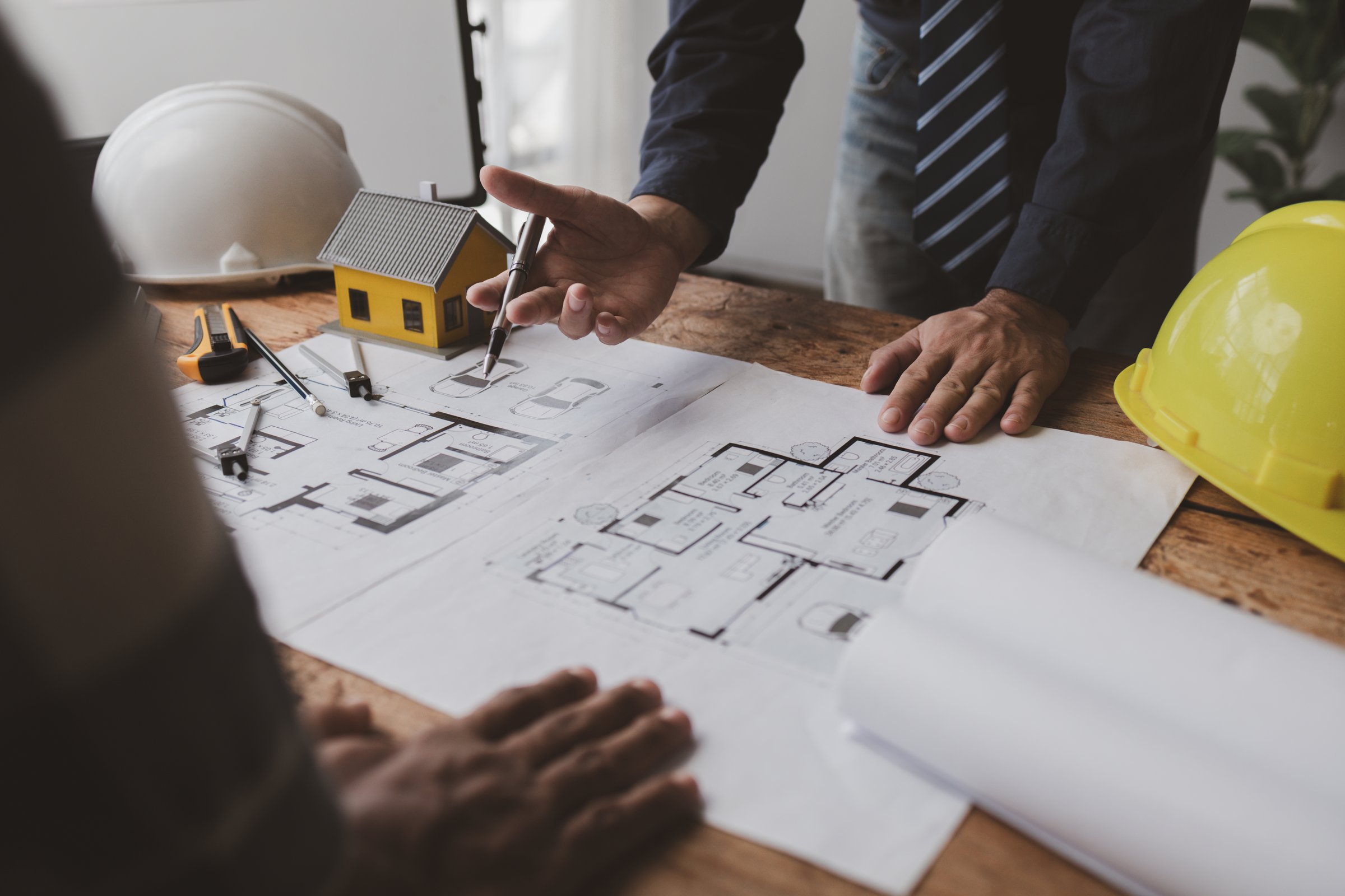 The home design architects are reviewing the house plan draft, the project commissioned by the client, and the custom design before delivery. Interior design and decoration ideas.