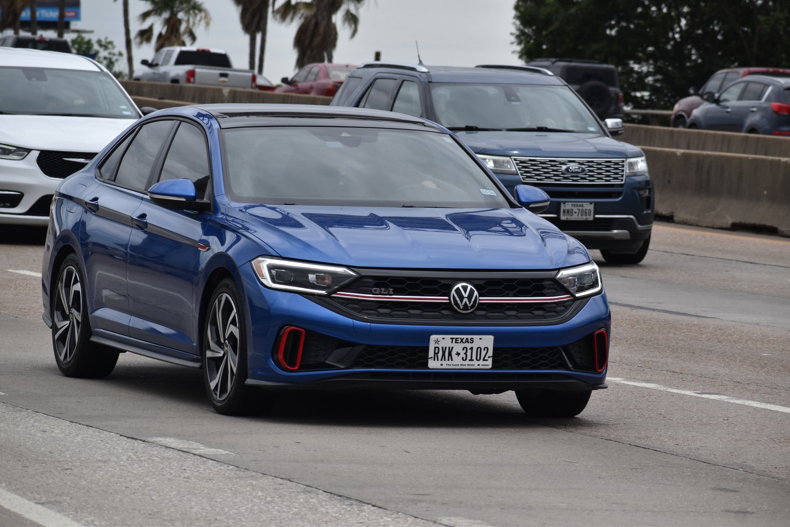 Houston, TX USA - 5/11/2024 - A portrait of a blue Volkswagen Jetta sedan traveling down a highway in moderate traffic