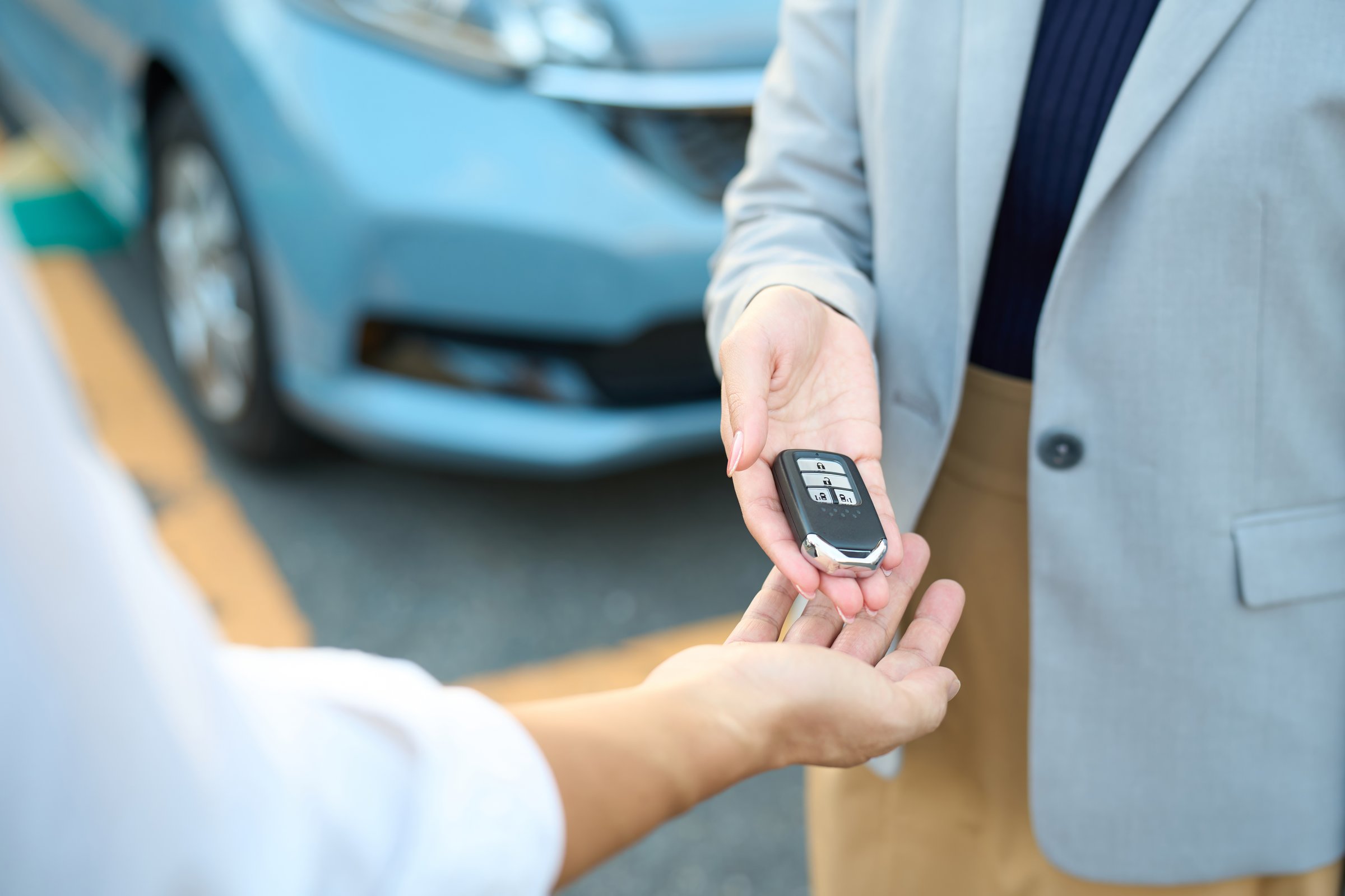 Woman handing over car keys outside