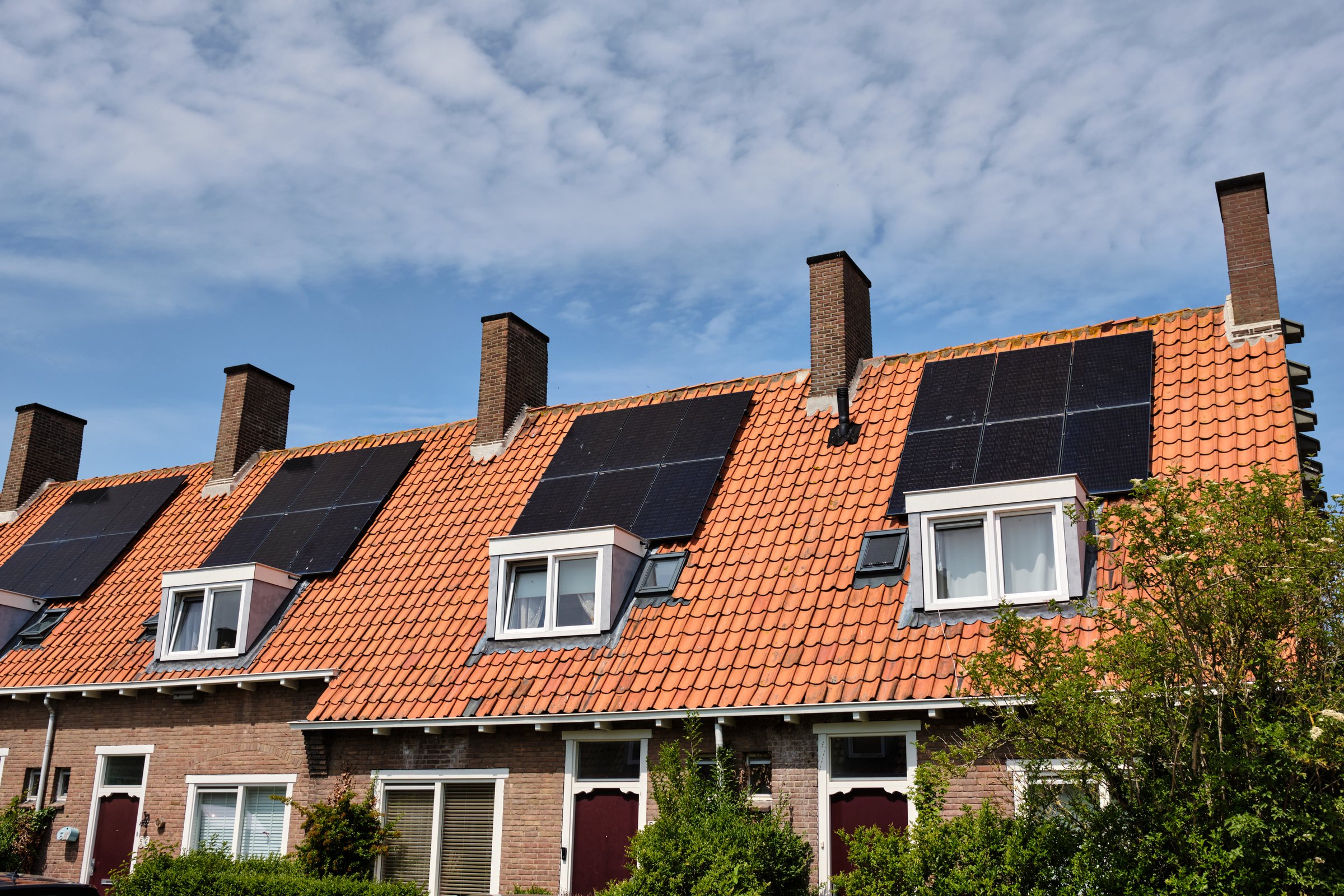 May 31, 2025 - Middelburg-Netherlands: Typical 1930 Social housing block with a repeating solar panels across multiple homes, and large chimney's, offering cheaper energy bills for household's.