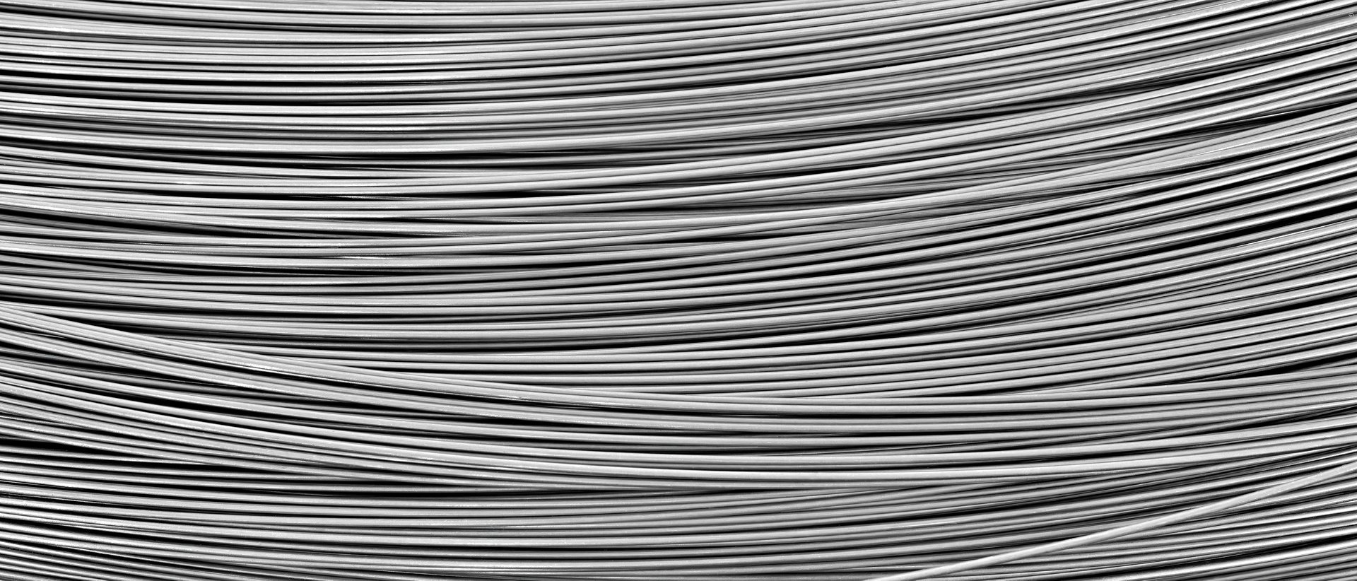 Long, thin, silver wire with many small lines. It is not clear what the wire is made of