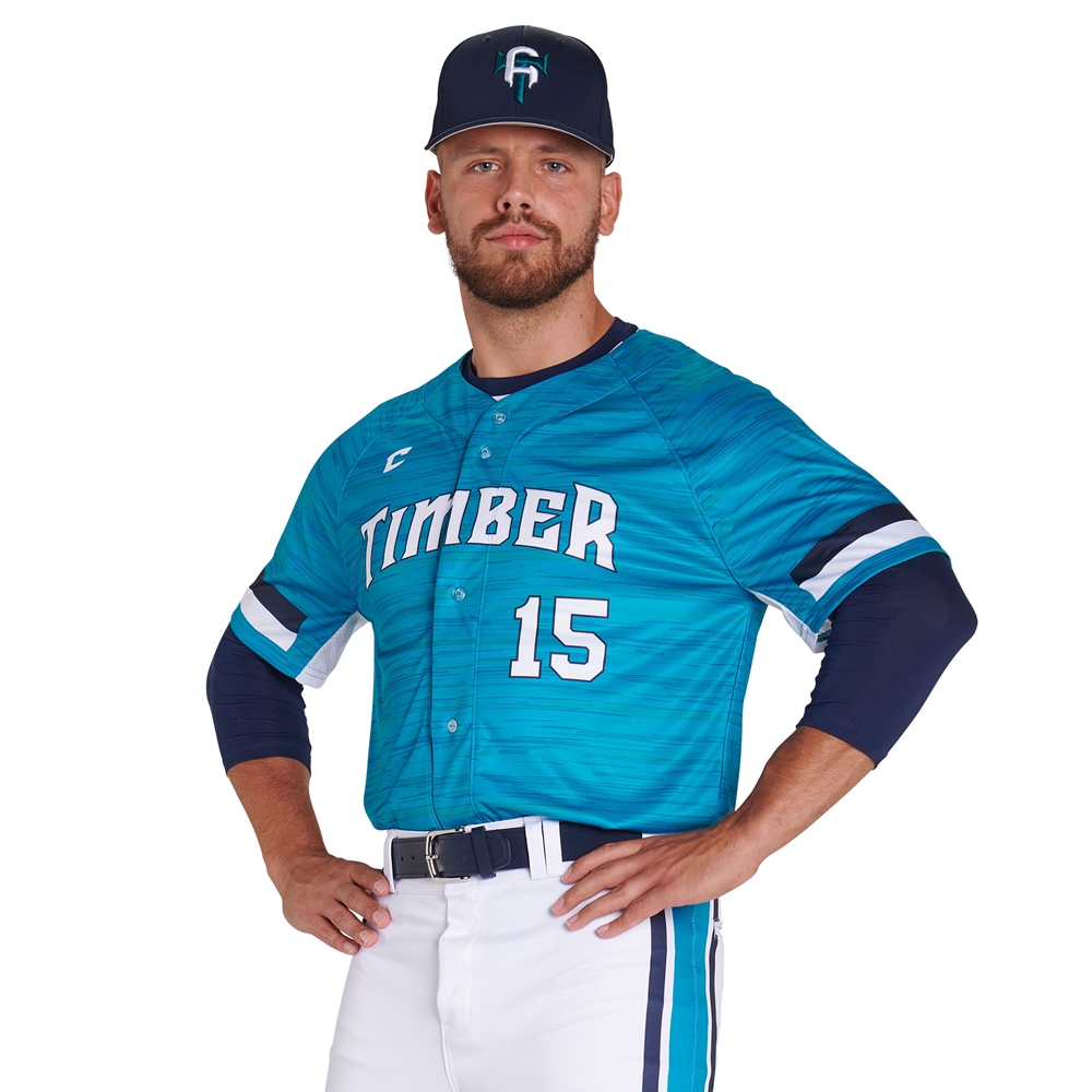 Baseball player in teal "Timber" jersey and cap, standing with hands on hips, number 15 visible on the jersey.